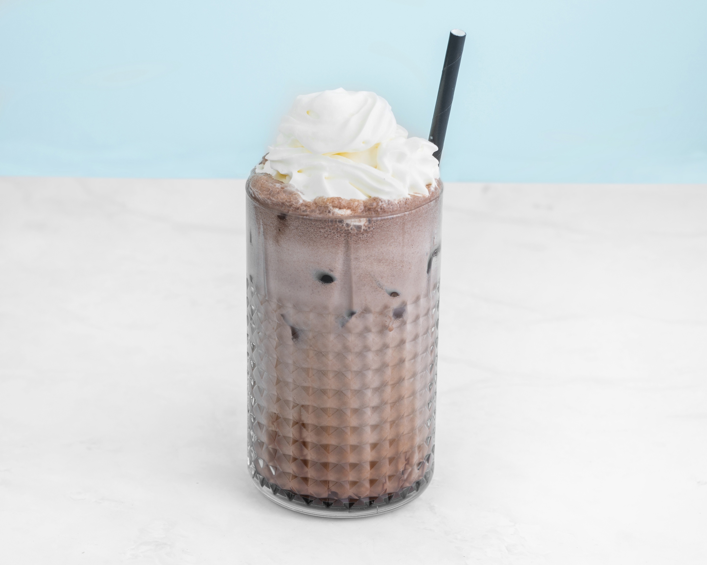 Iced chocolate drink topped with whipped cream
