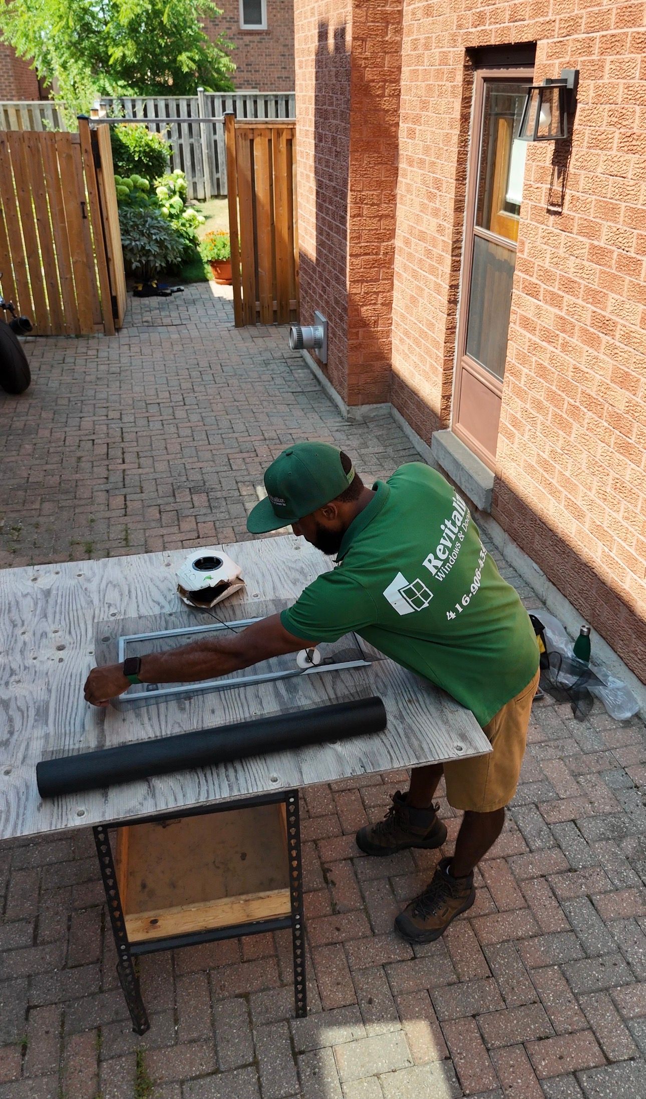 Revitalize Windows & Doors technician adding new mesh to a torn window screen on-site