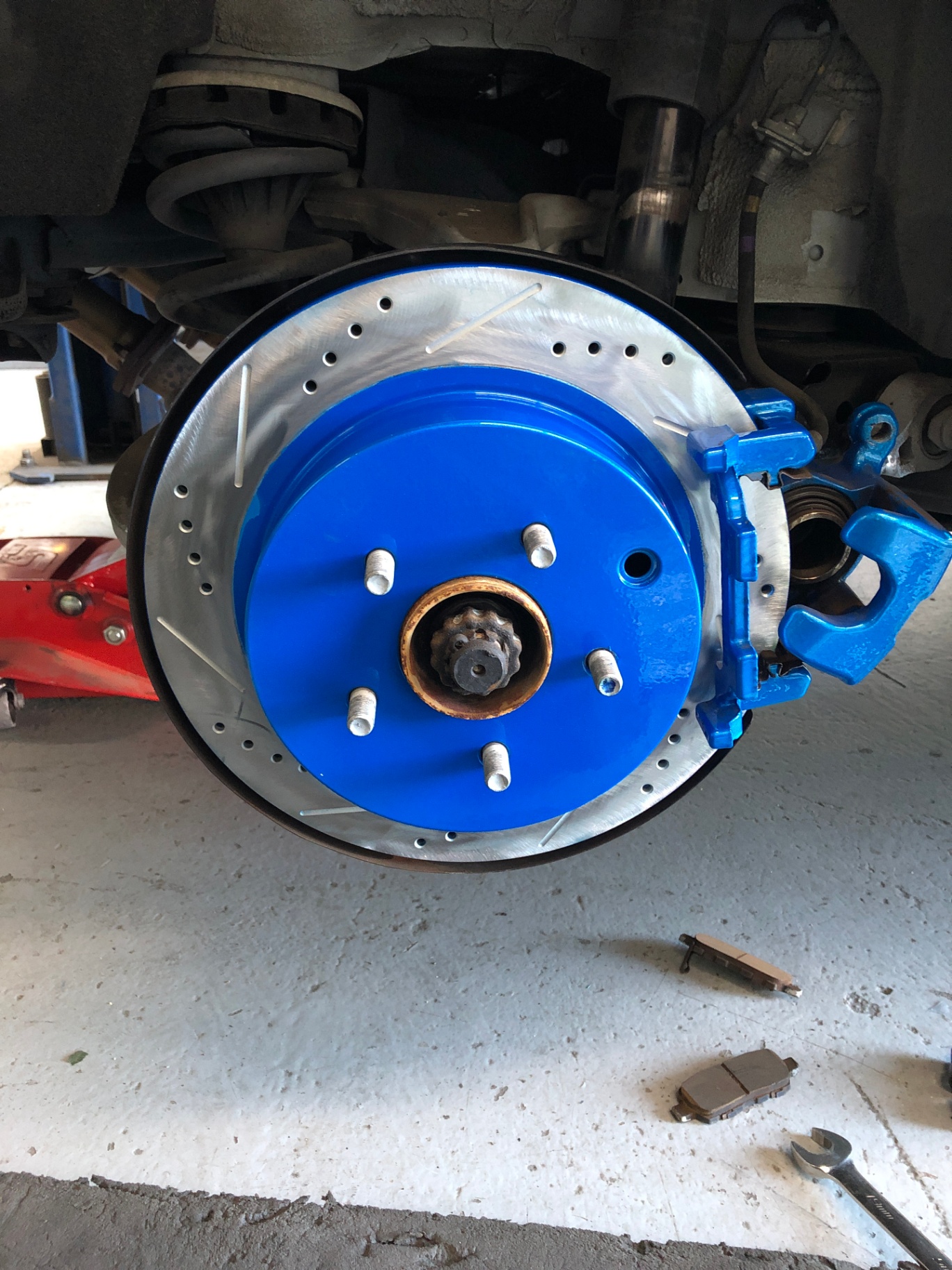 Close-up of a car's wheel assembly showing custom blue powder coating