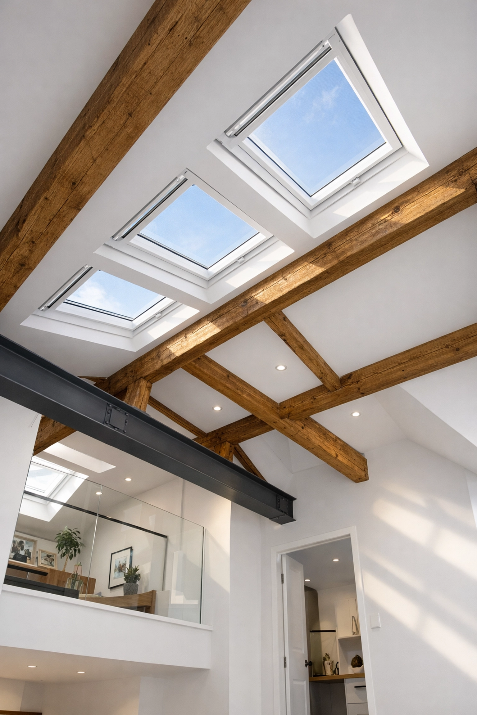 Modern loft conversion in London with exposed beams and skylights showing residential architecture design