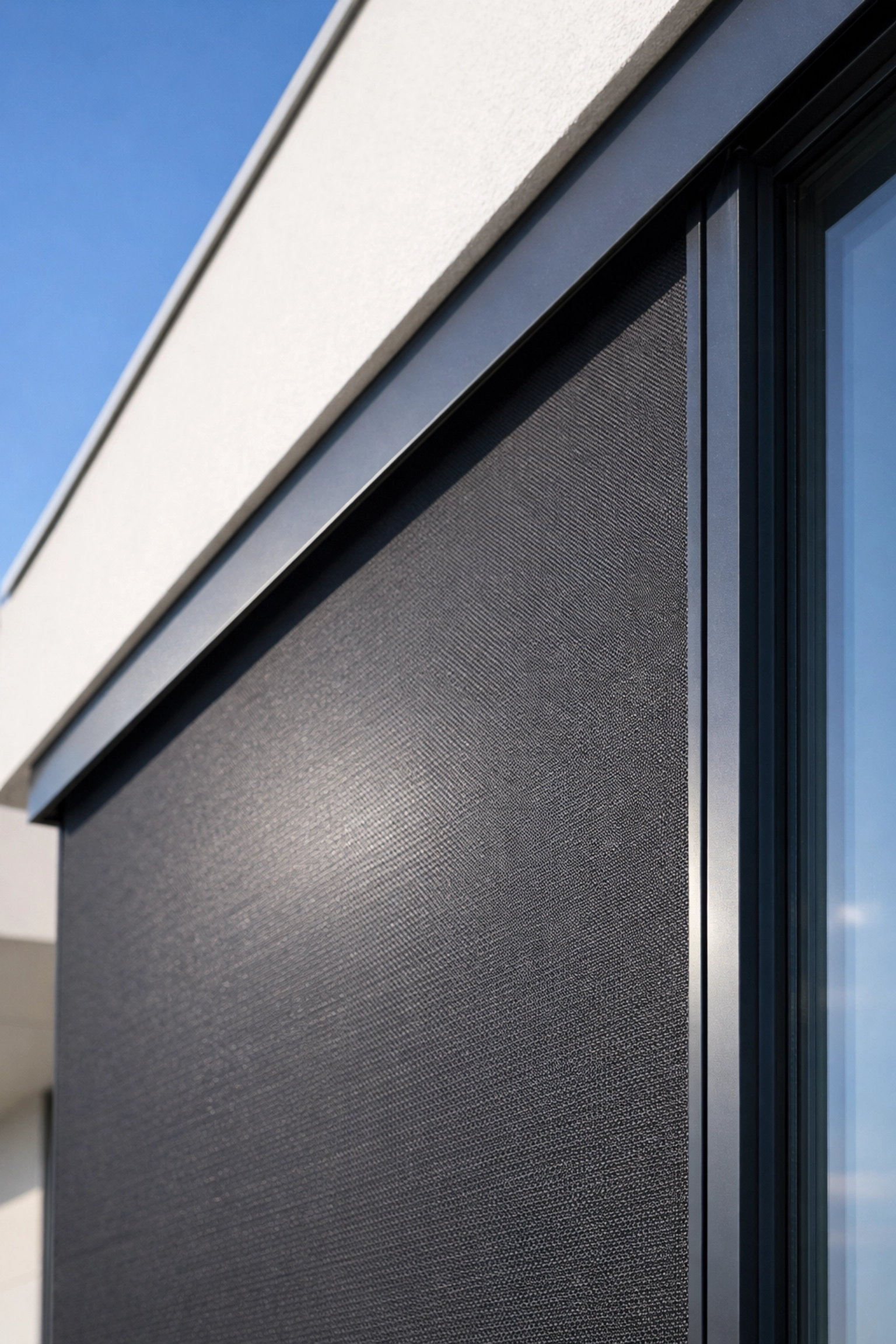 Moderner Zip Screen Wien an einer Penthouse-Glasfassade für eleganten, lichtdurchlässigen Sonnenschutz.