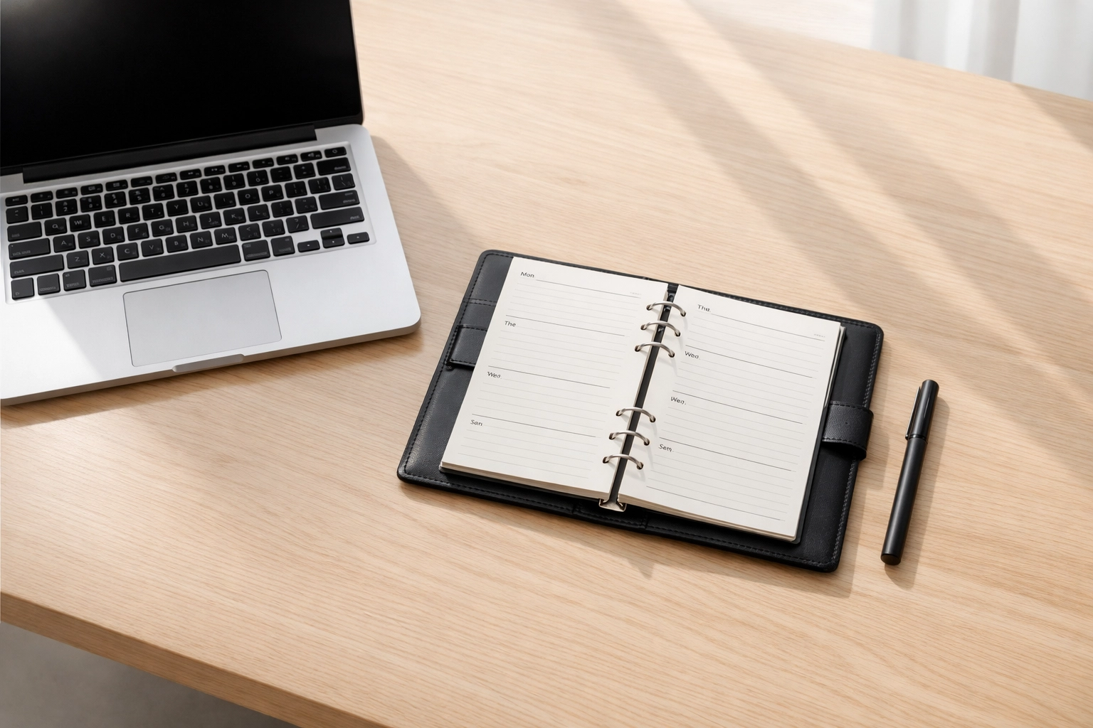 Modern office desk with a laptop and planner representing organized tax business scaling and cost mapping.