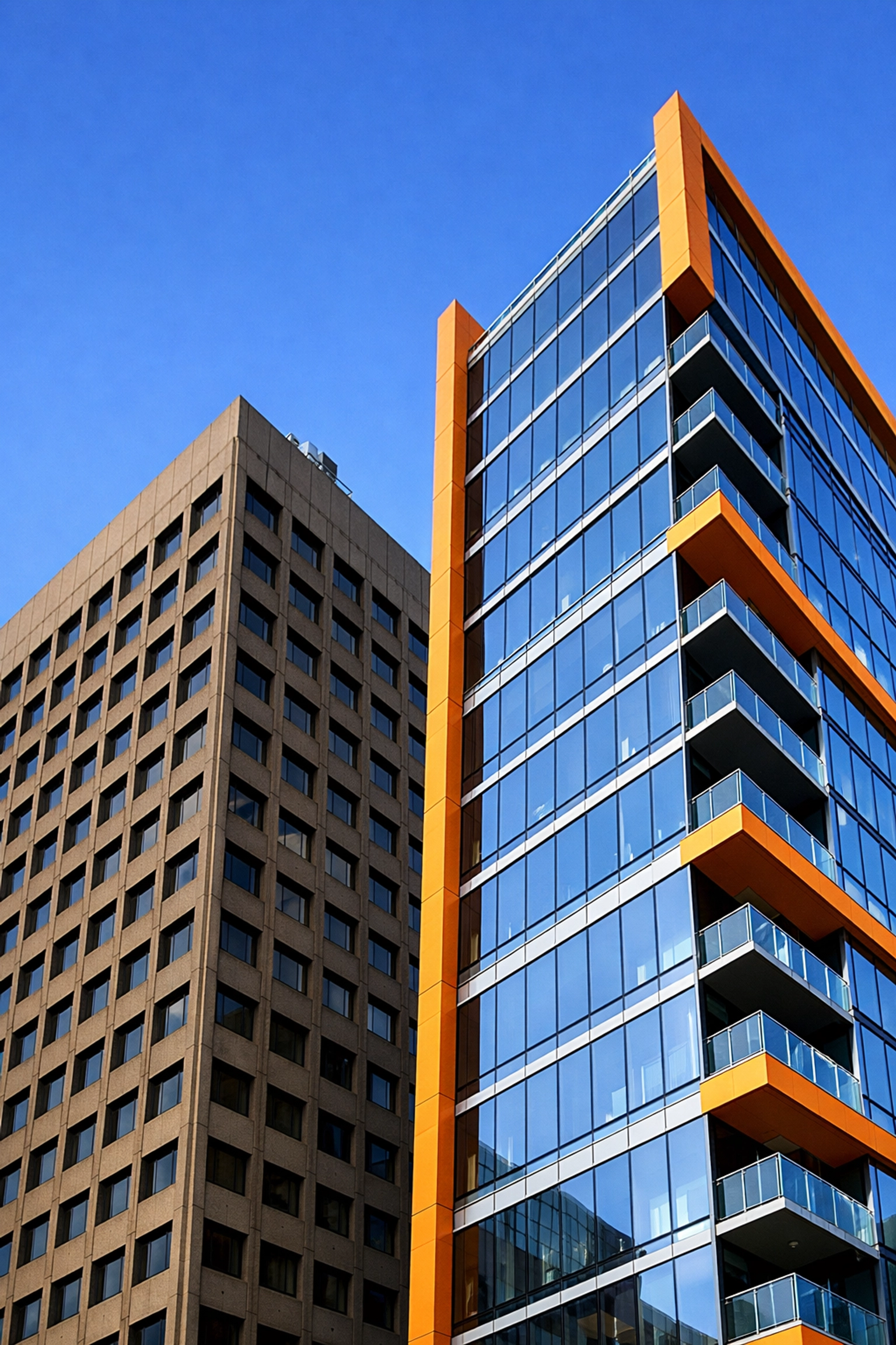 Comparison of legacy 1970s office building next to modern glass tower in San Francisco