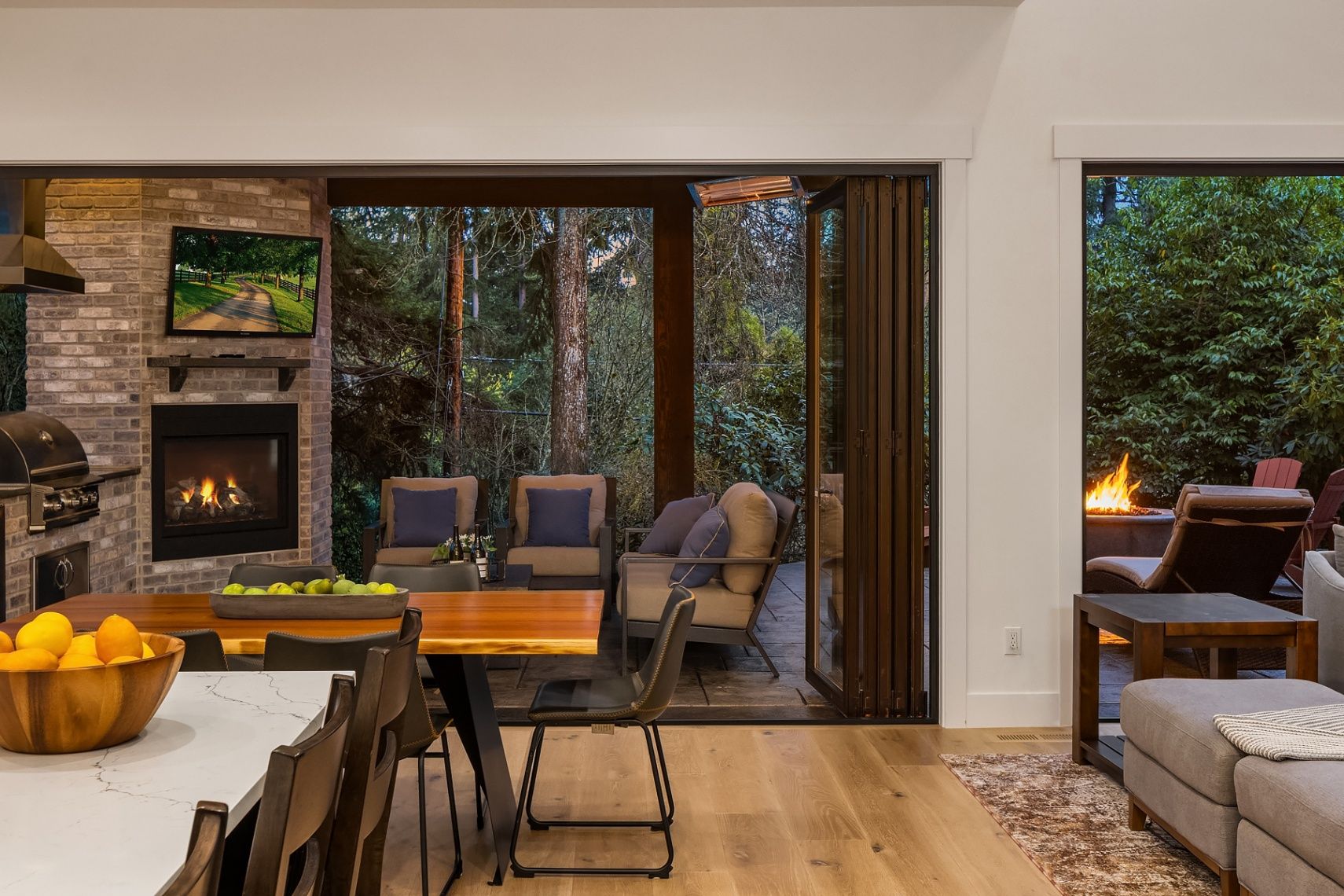 Sleek kitchen/dining area and outdoor lounge with fire pit