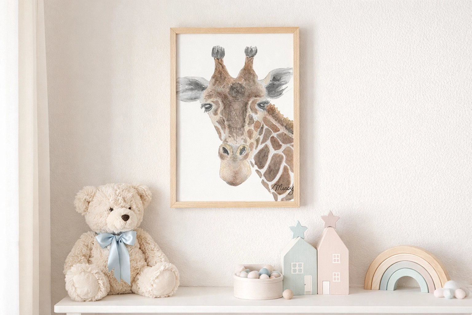 Lifestyle mockup of Missy’s signed giraffe watercolor print framed on a nursery wall