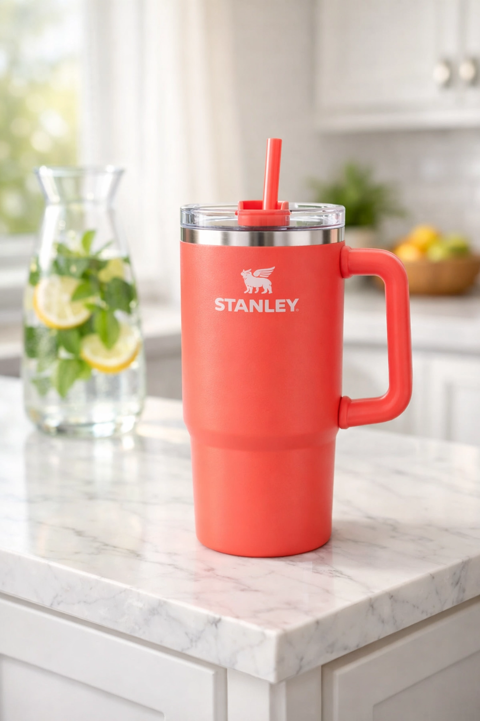 Hot Coral Stanley Quencher on a marble counter, highlighting sustainable design and vibrant style.