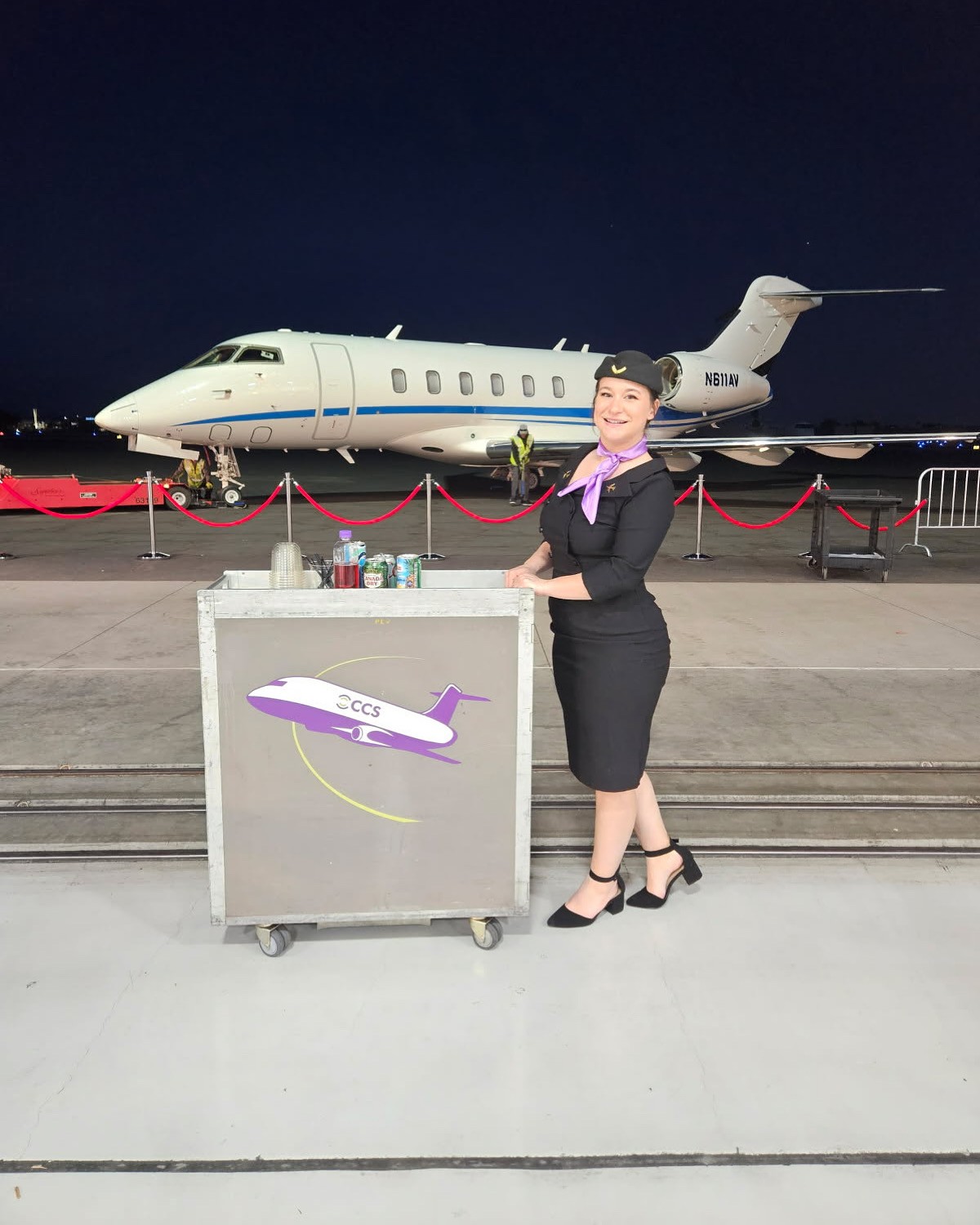A beverage service station set up in front of a private jet at night