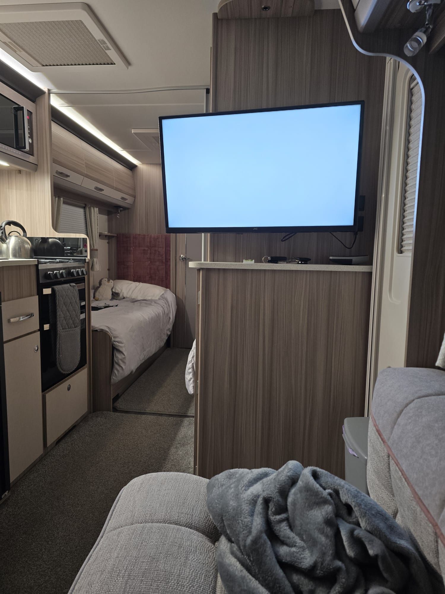 A cozy evening inside the Coachman Acadia showing the modern kitchen and lounge area