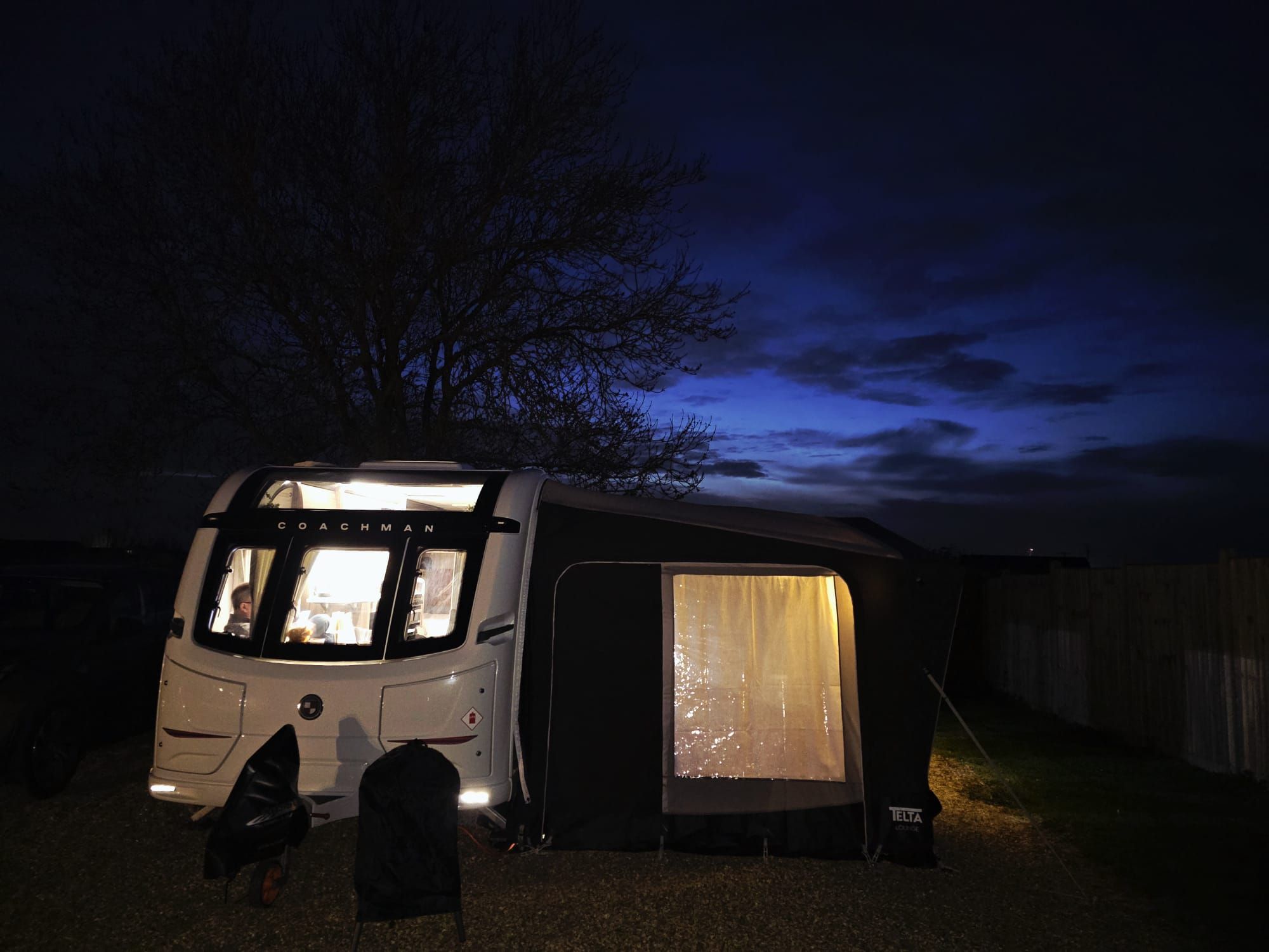 Coachman Acadia 565 caravan with a Telta awning warmly lit at dusk