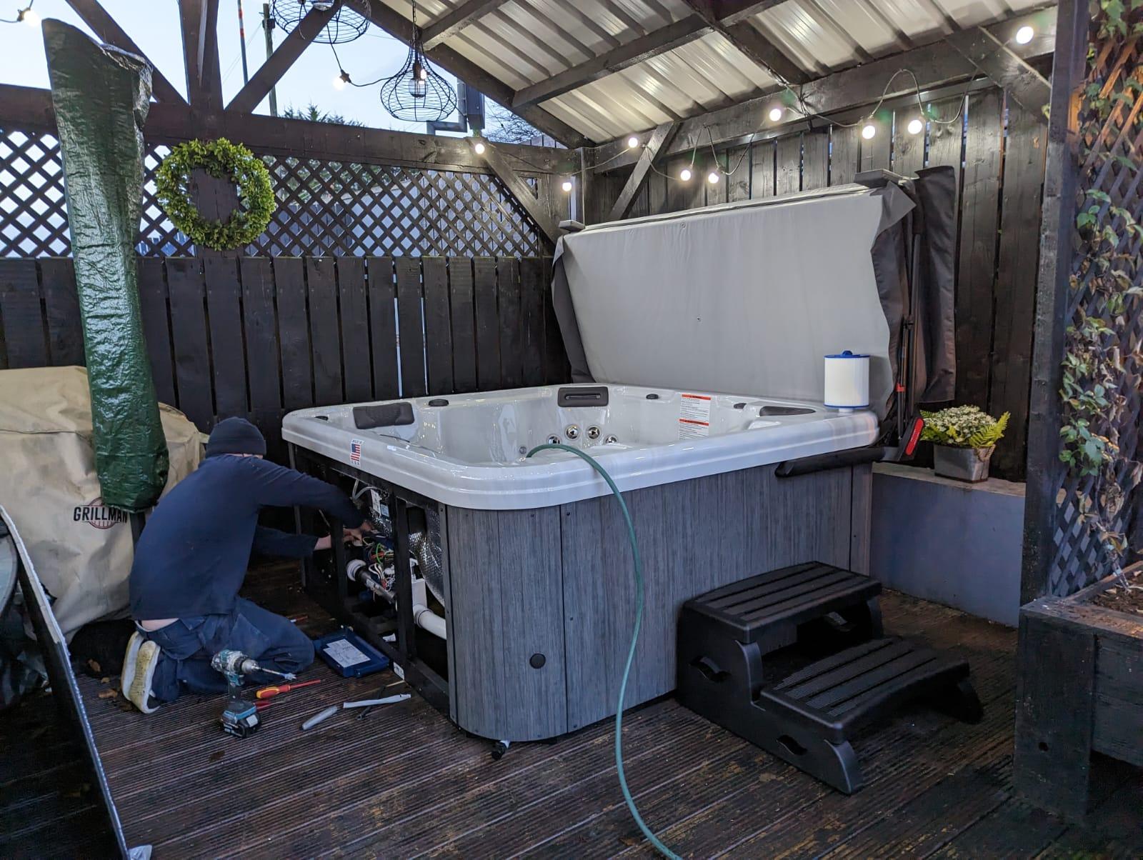 A Fiesta Spas installation specialist performs routine maintenance on a premium Artesian Spa