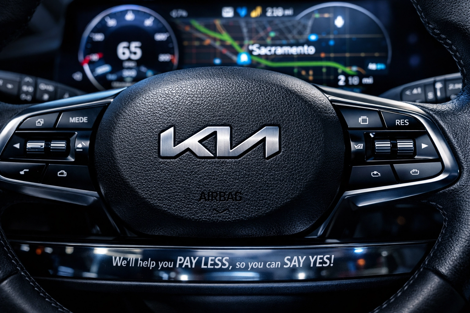 Detailed view of the new Kia logo on a modern steering wheel with a high-tech digital dashboard display.