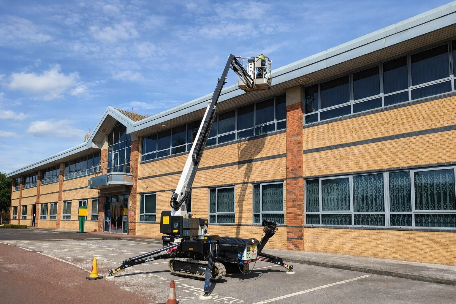Commercial gutter cleaning using a cherry picker on a building in Altrincham.