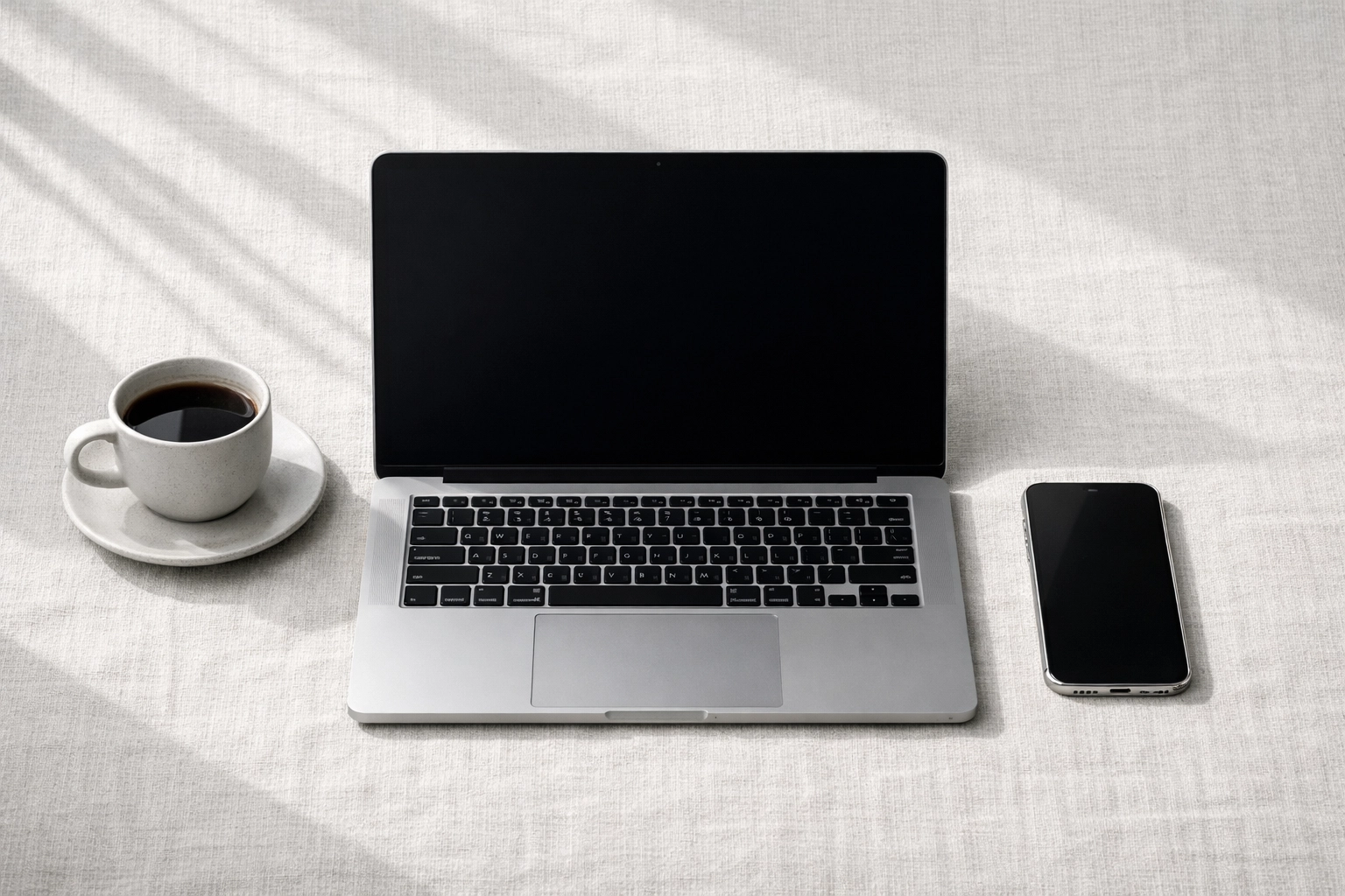 Laptop and phone used for remote hotel management via a cloud-native PMS platform.