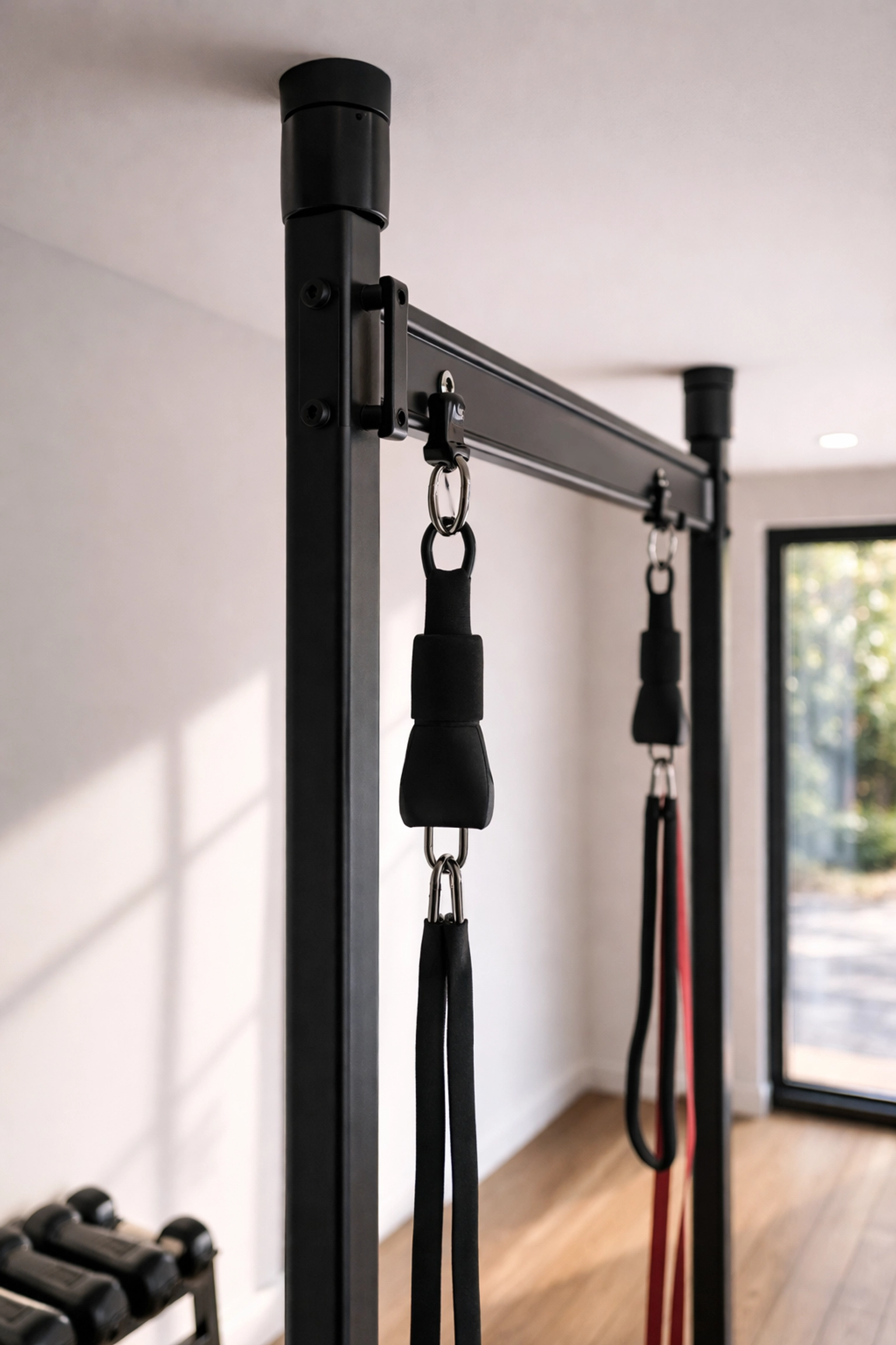 Close-up of a floor-to-ceiling resistance rail system in a modern home gym, showing secure installation with no wall damage.