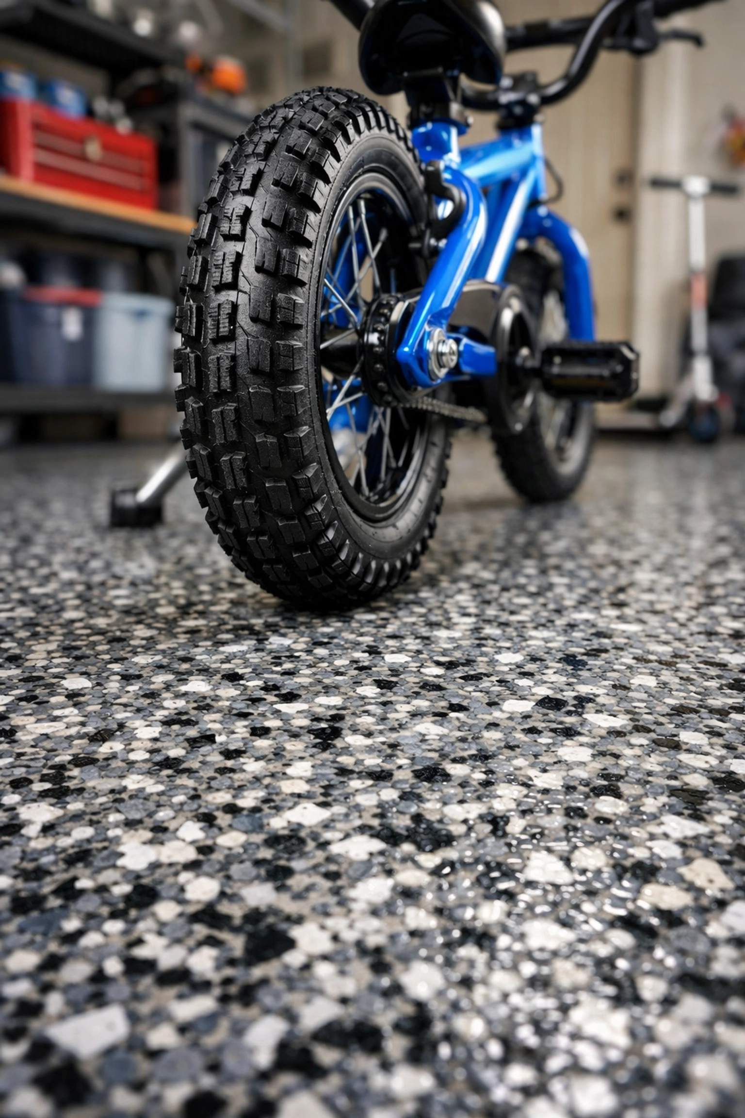 Slip-resistant polymer flake garage flooring with a child’s bike for family safety.