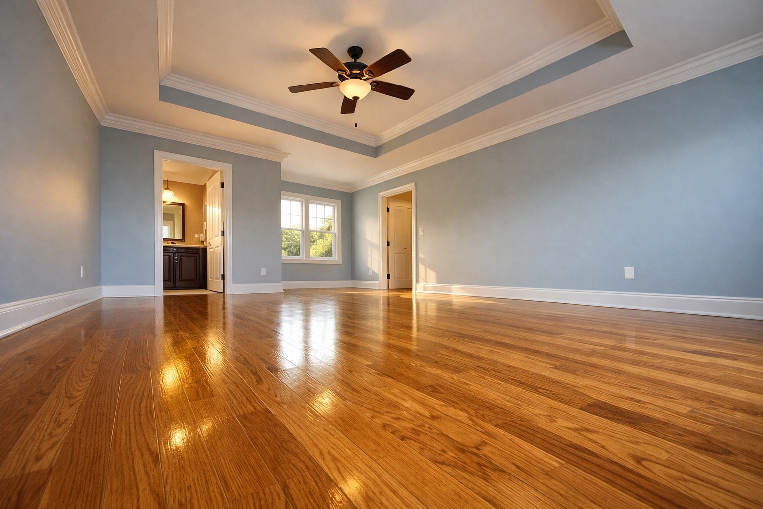 Empty master suite with polished hardwood floors after a professional move-out deep clean in Groton, MA.