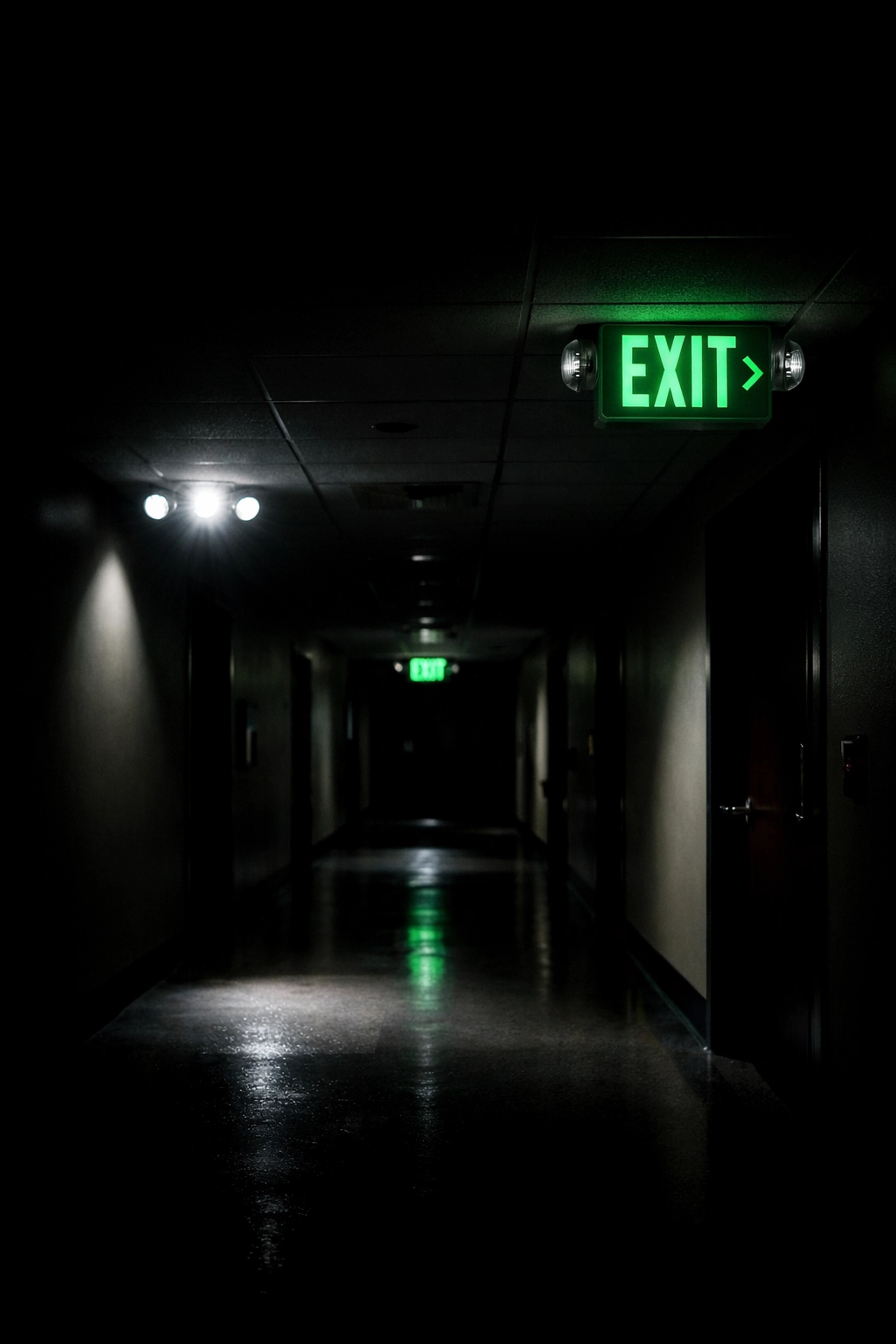 Emergency lighting illuminated in commercial building corridor during power outage