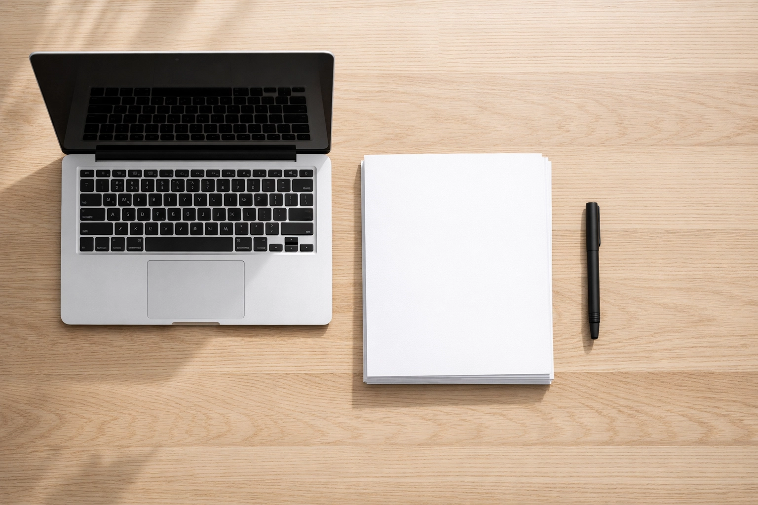 Minimalist tax professional workspace with a laptop and papers, highlighting 2026 filing efficiency.