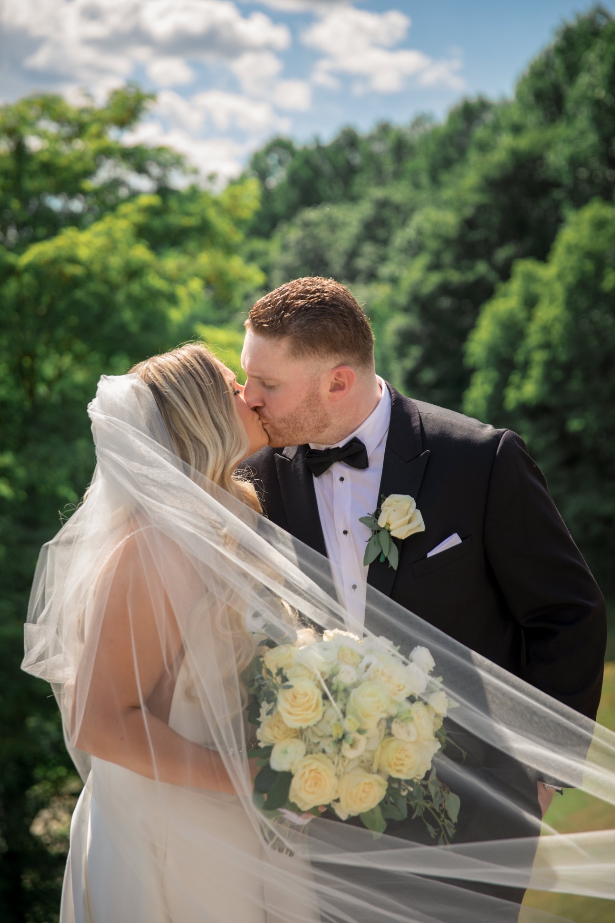 Bride and groom share a kiss outdoors