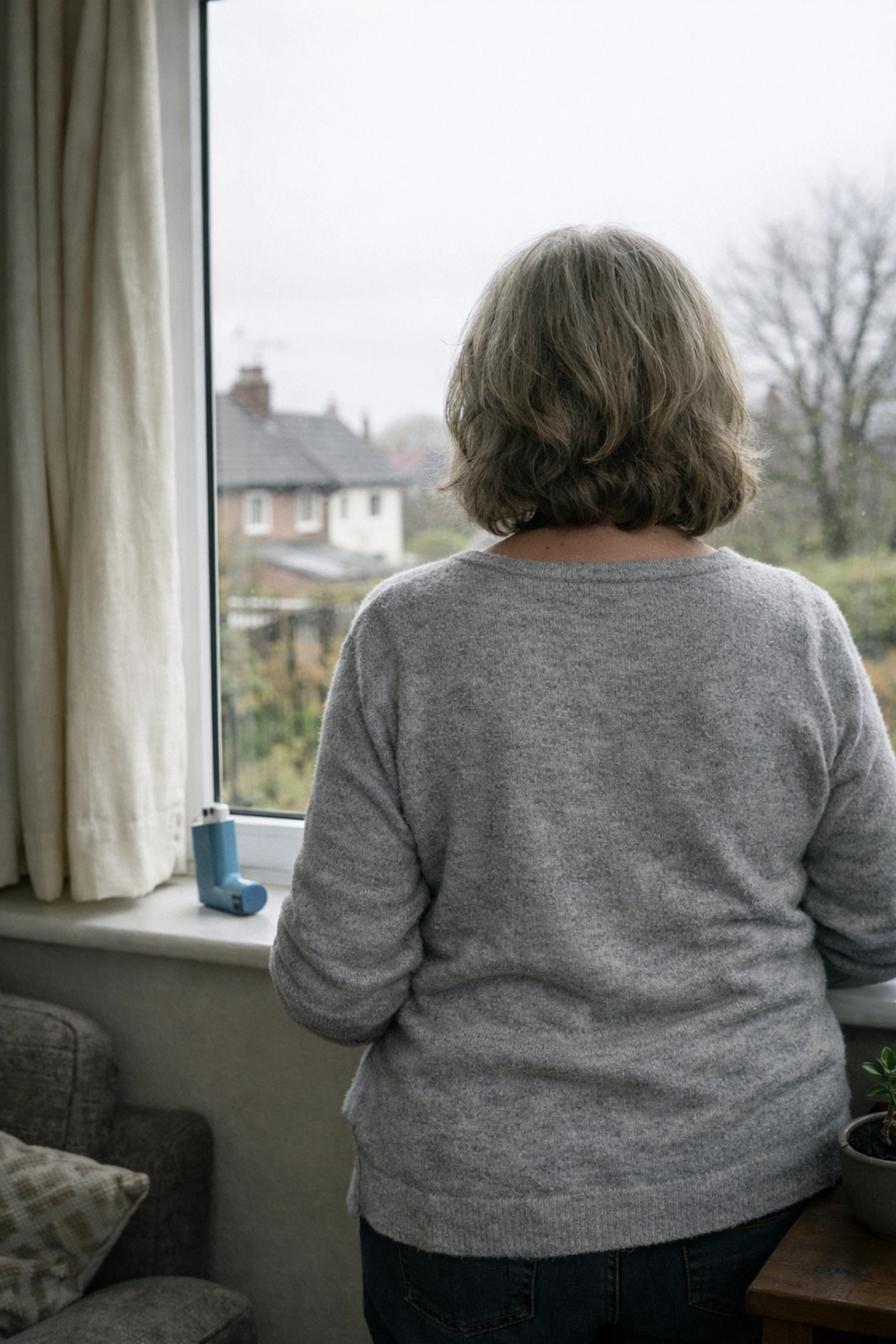 Person living with asthma at home with blue reliever inhaler