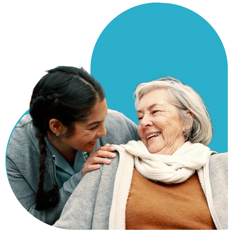 Compassionate caregiver and senior woman sharing a joyful moment