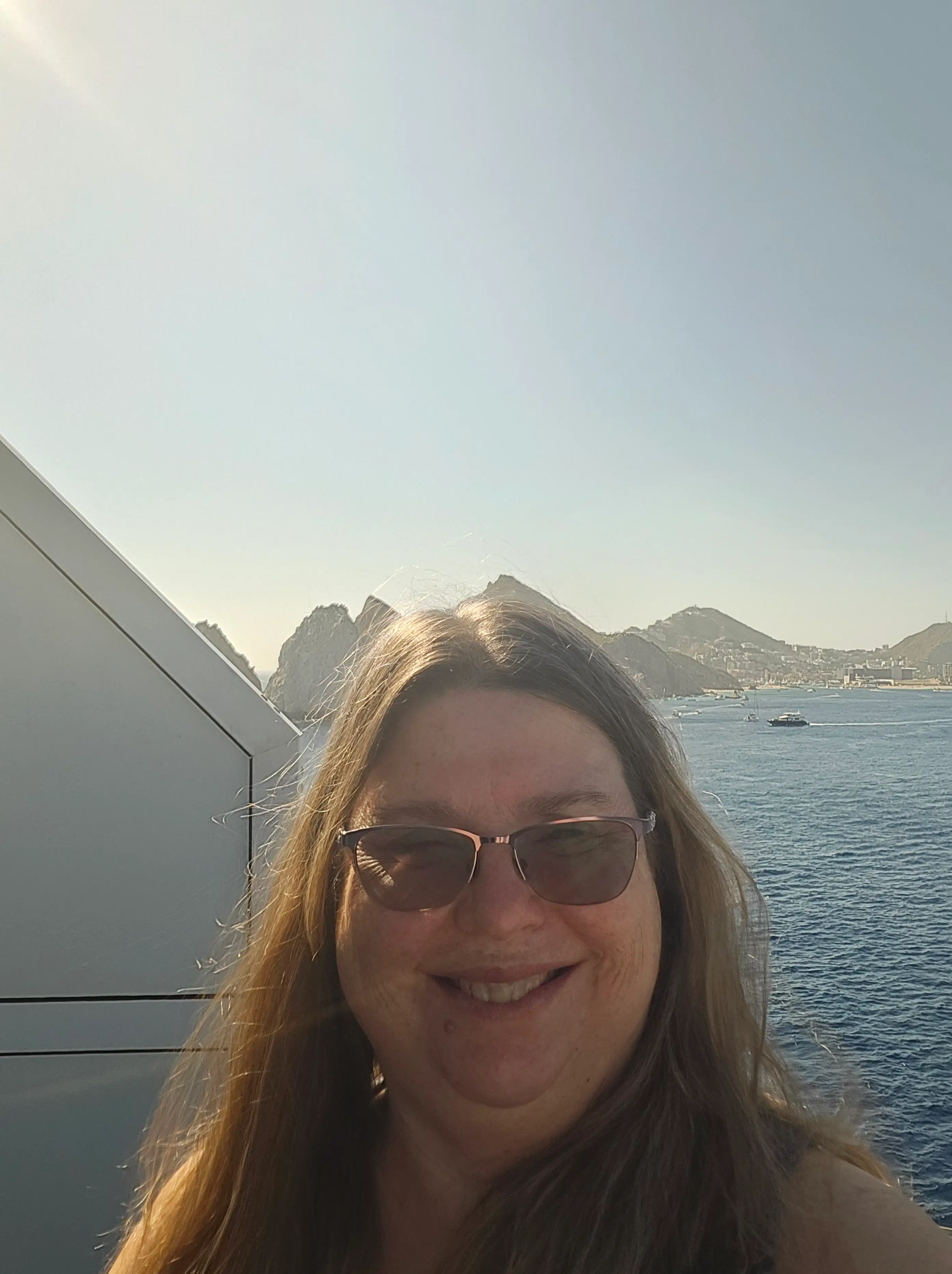 Kim Frink enjoying a sunny ocean view from a cruise ship balcony