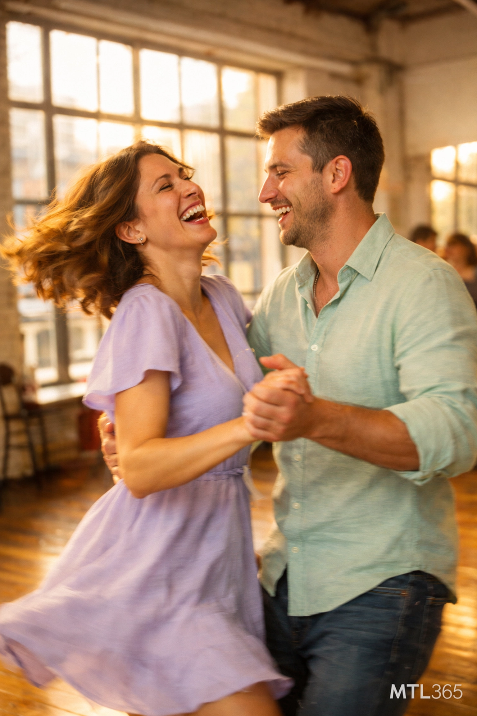 A couple dancing at the Bachata Nights Spring Blossom party in a sun-drenched Montreal dance studio.