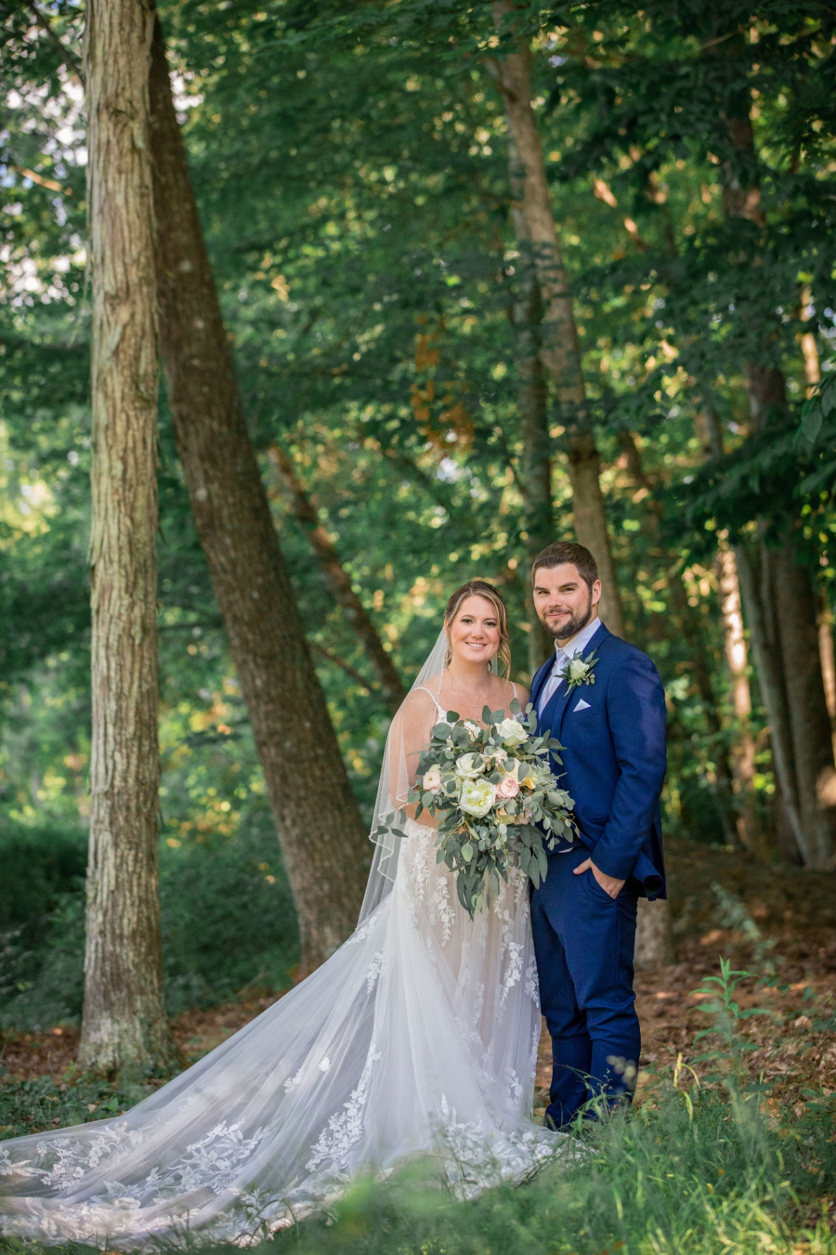 Close-up of the couple standing together in the vibrant greenery of the forest