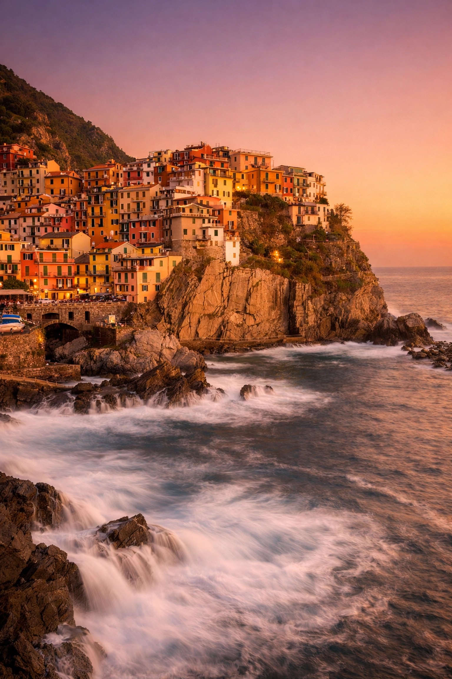 Iconic photography location Manarola in Cinque Terre, Italy featuring colorful coastal houses at sunset.
