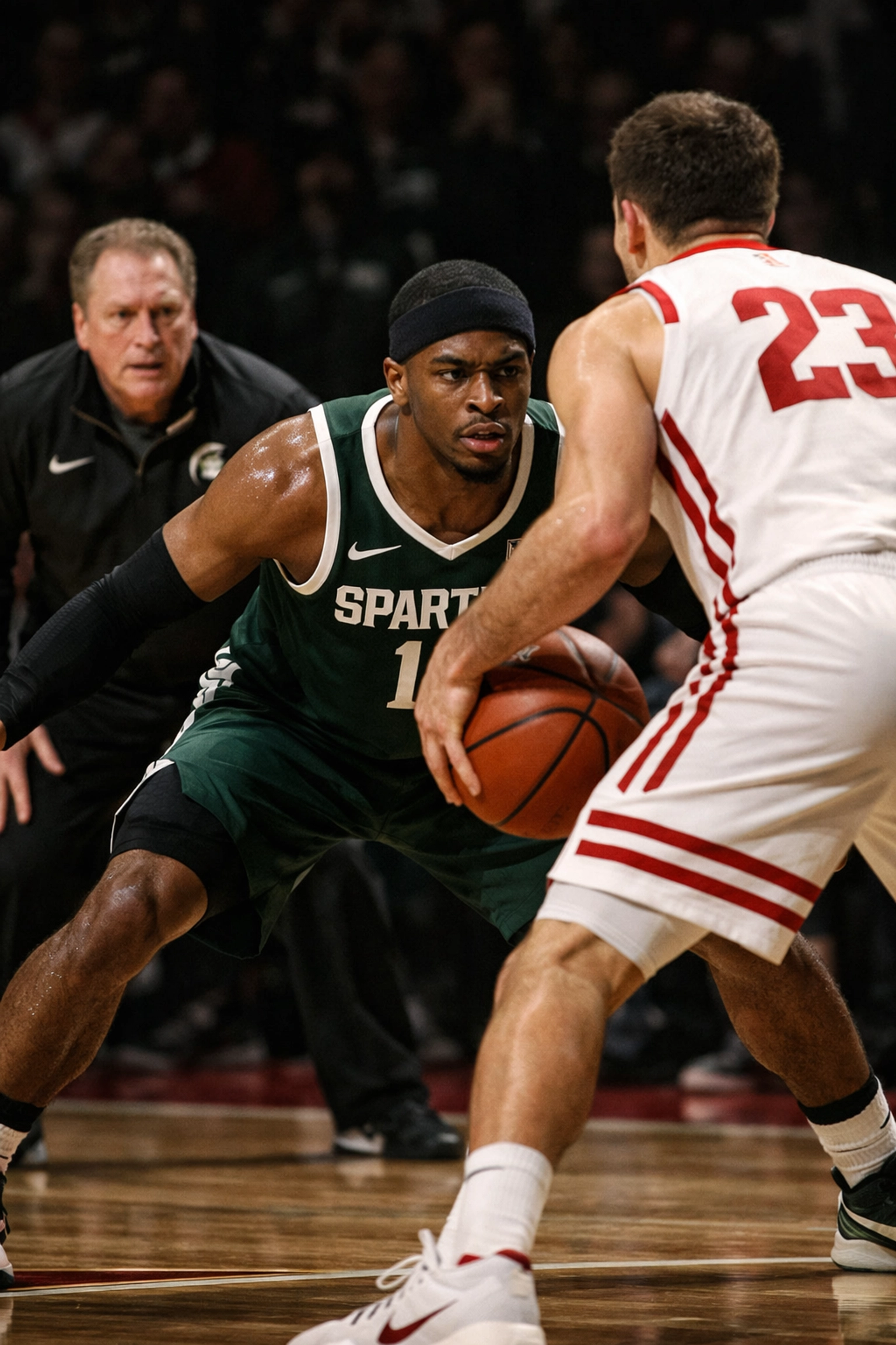Michigan State Spartans and Wisconsin Badgers players compete in a physical Big Ten conference basketball matchup.