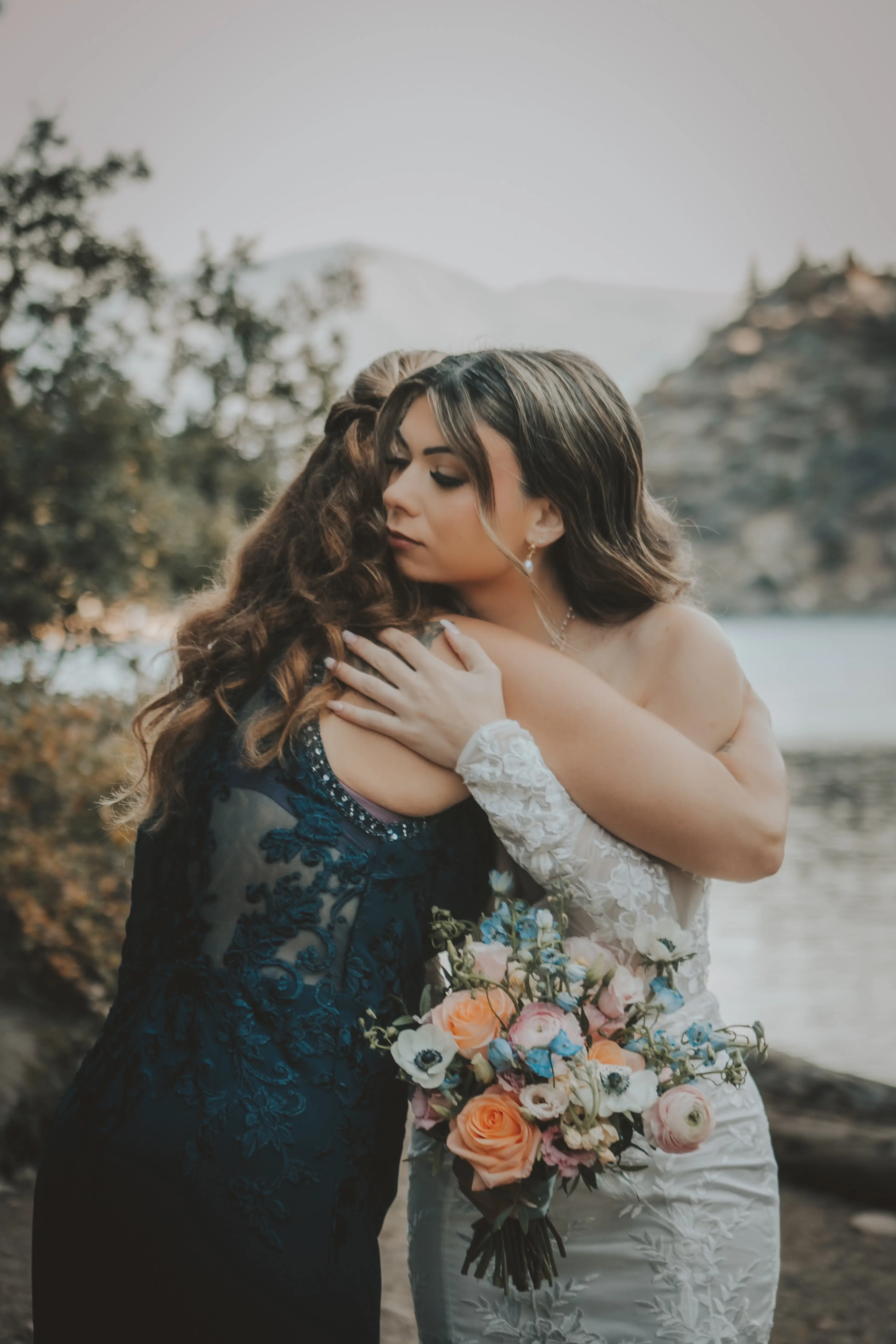 bride-embracing-woman-lake-banff-canadian-rockies.webp