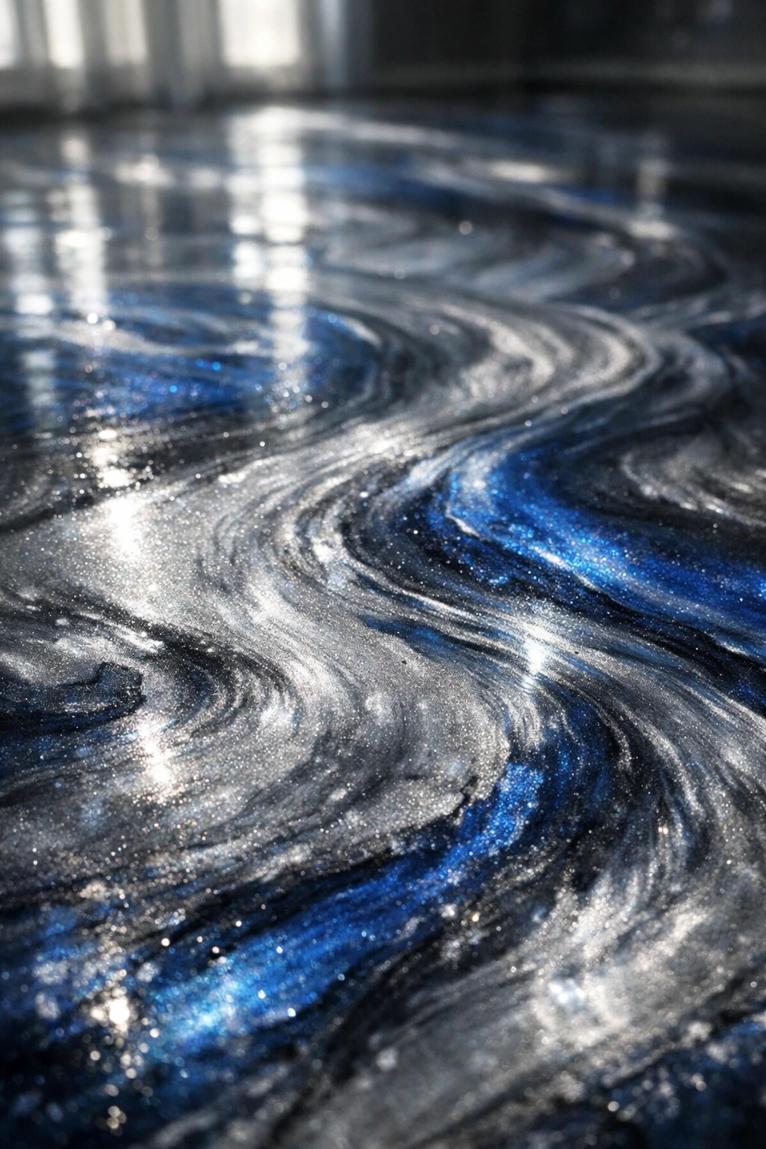 Metallic epoxy flooring with silver and blue marble-like swirls showing custom patterns