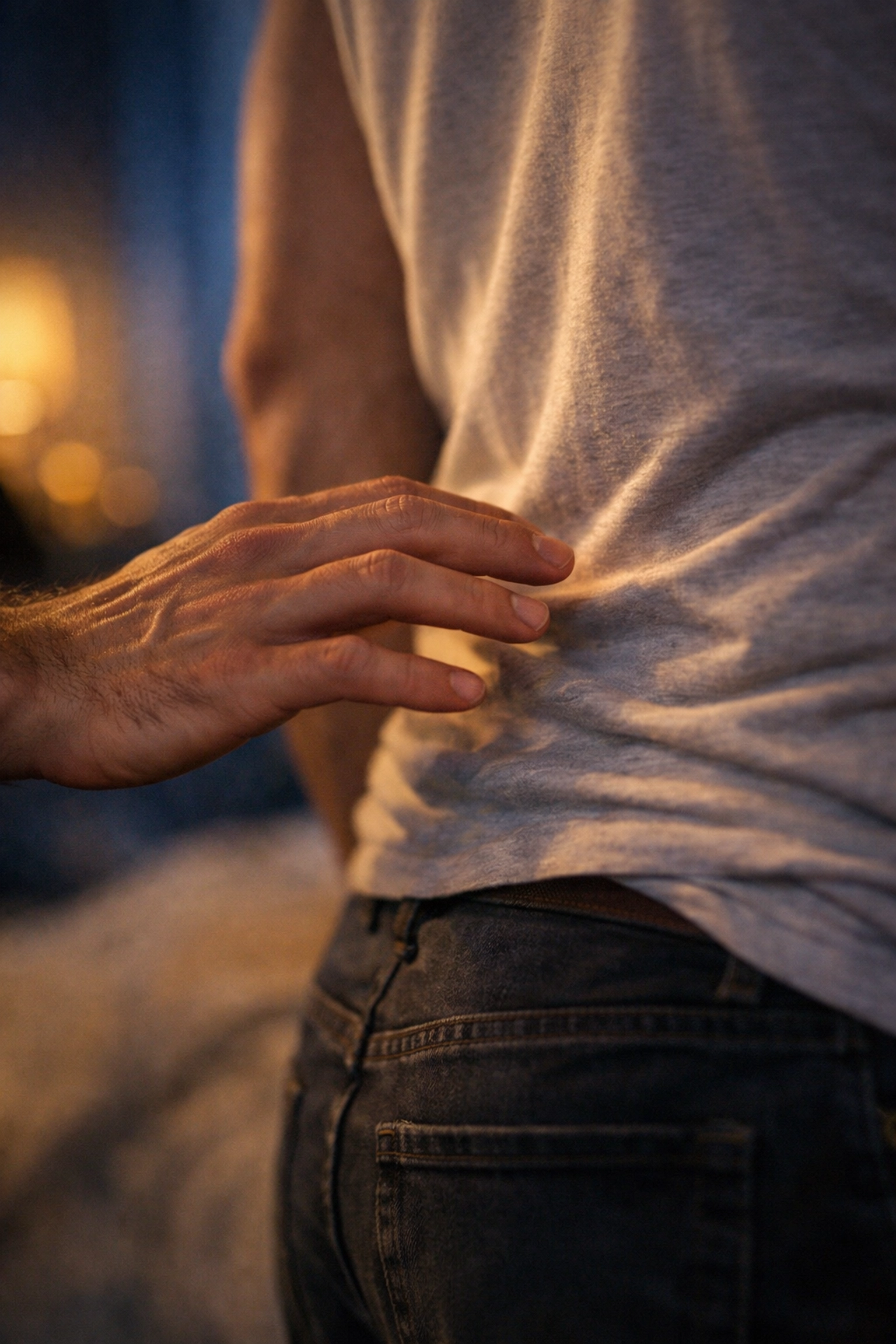 A hand hovers near a man's back, illustrating the physical tension and anticipation in gay love stories.