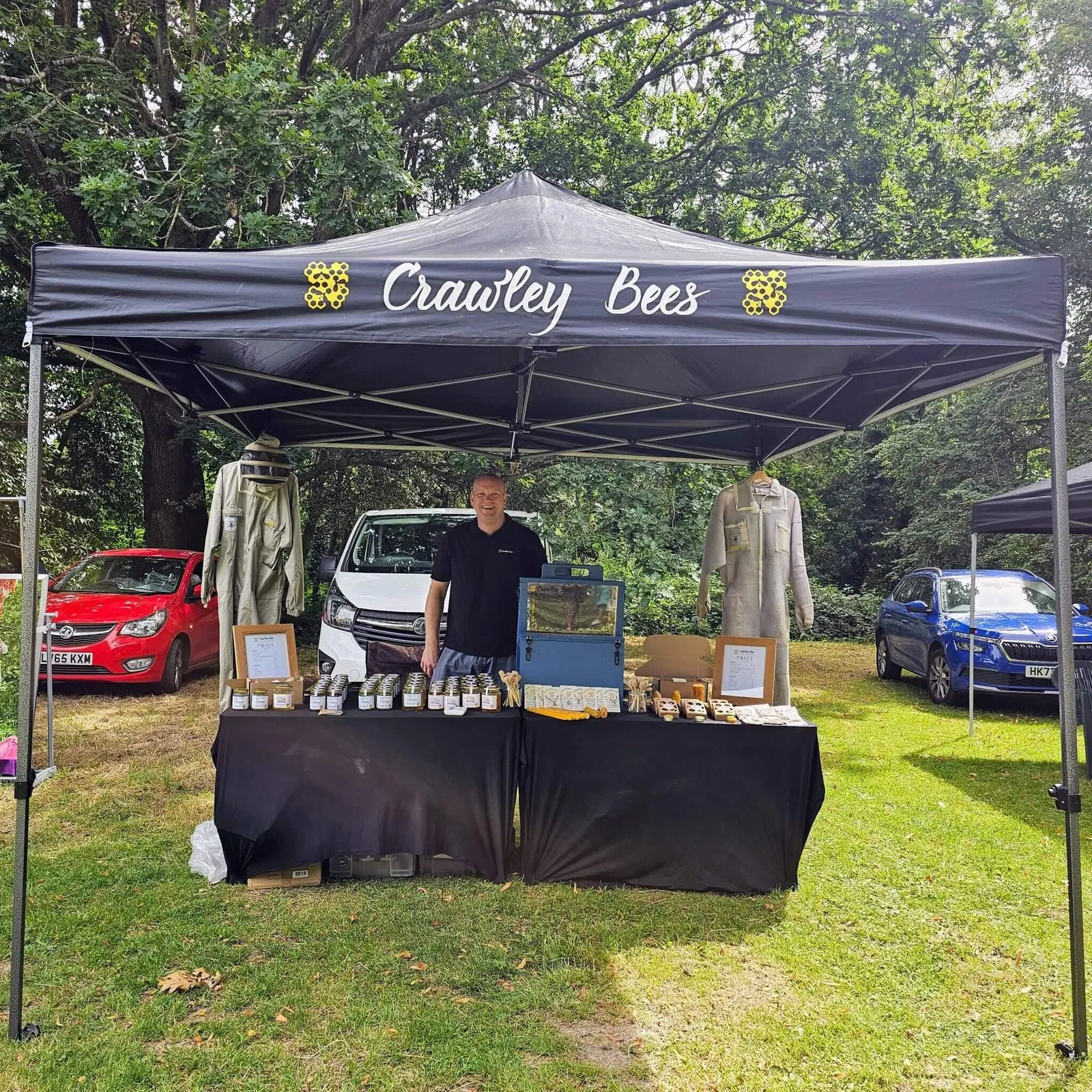 Crawley Bees market stall featuring jars of single-source honey and beeswax products.