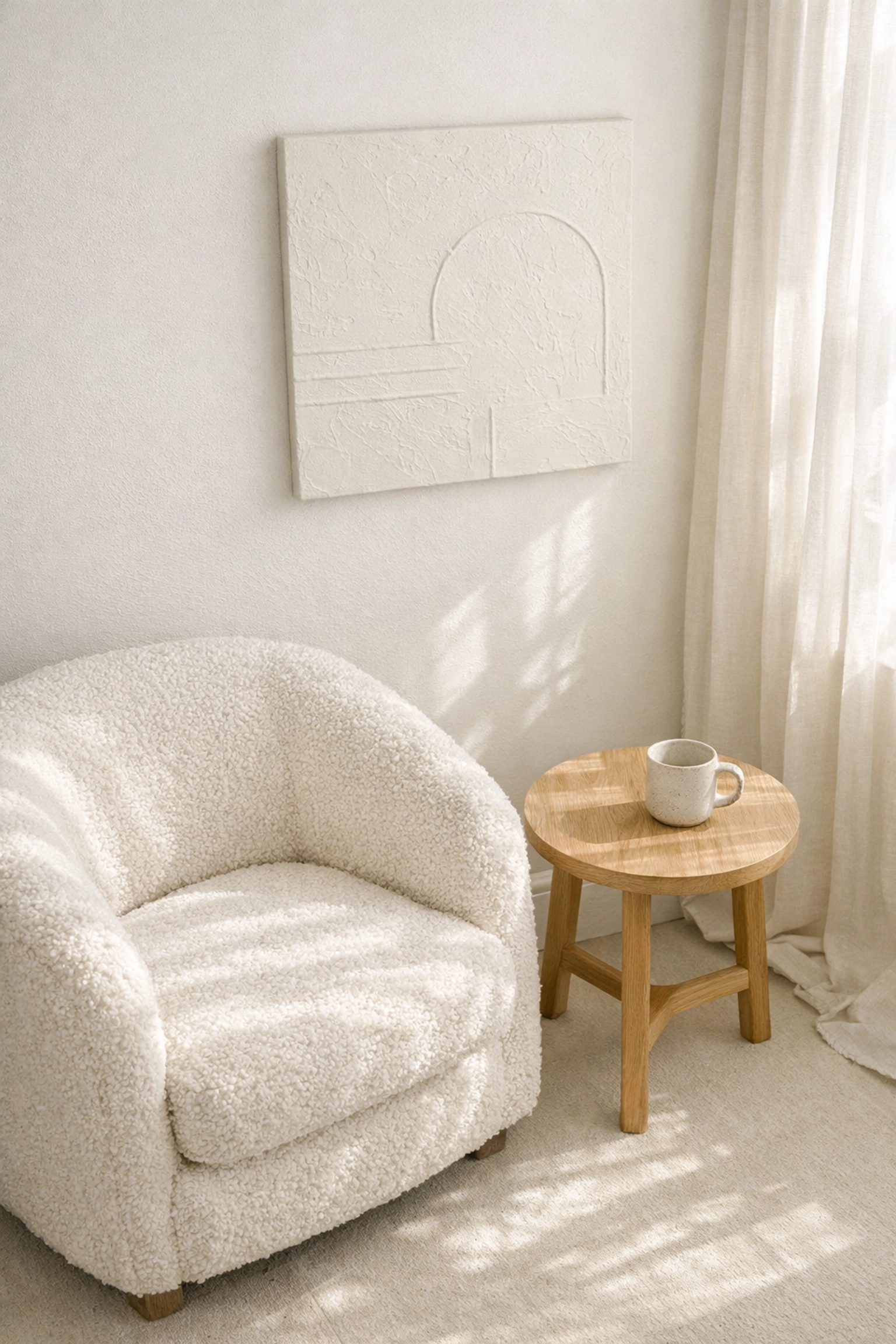 Serene minimalist reading nook styled in Cloud Dancer white with a plush boucle armchair.