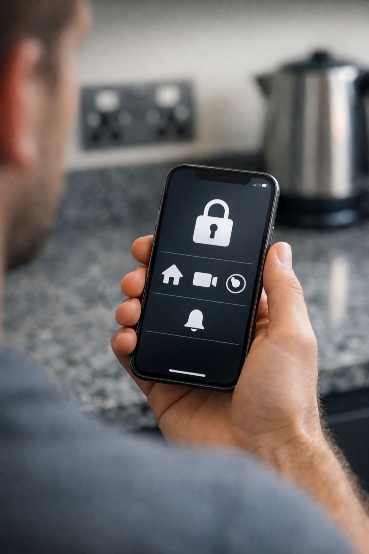 Controlling a smart home security system via mobile app in a modern Basingstoke kitchen.