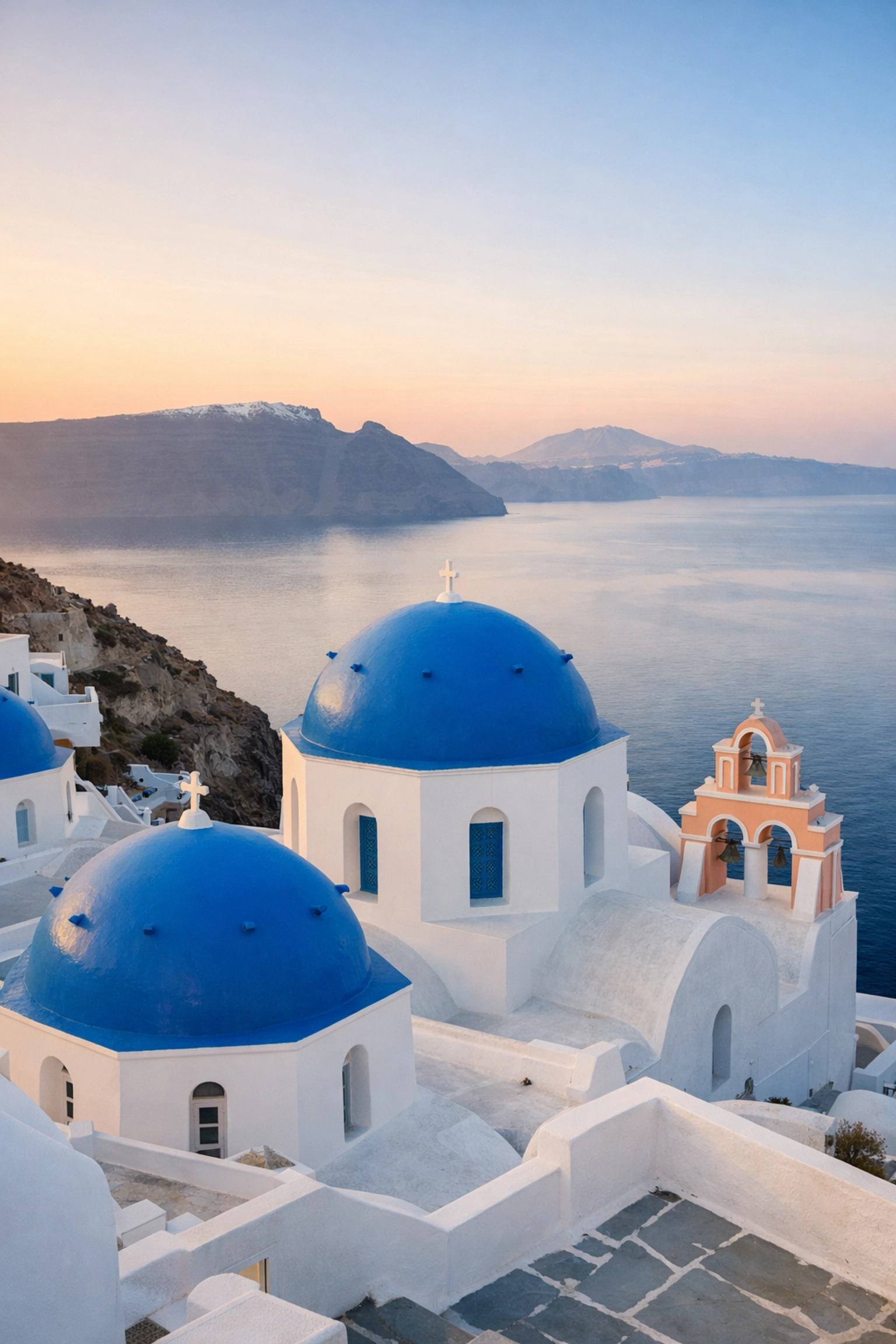 Sunrise at the famous blue dome churches in Oia, a top instagrammable place in Santorini.