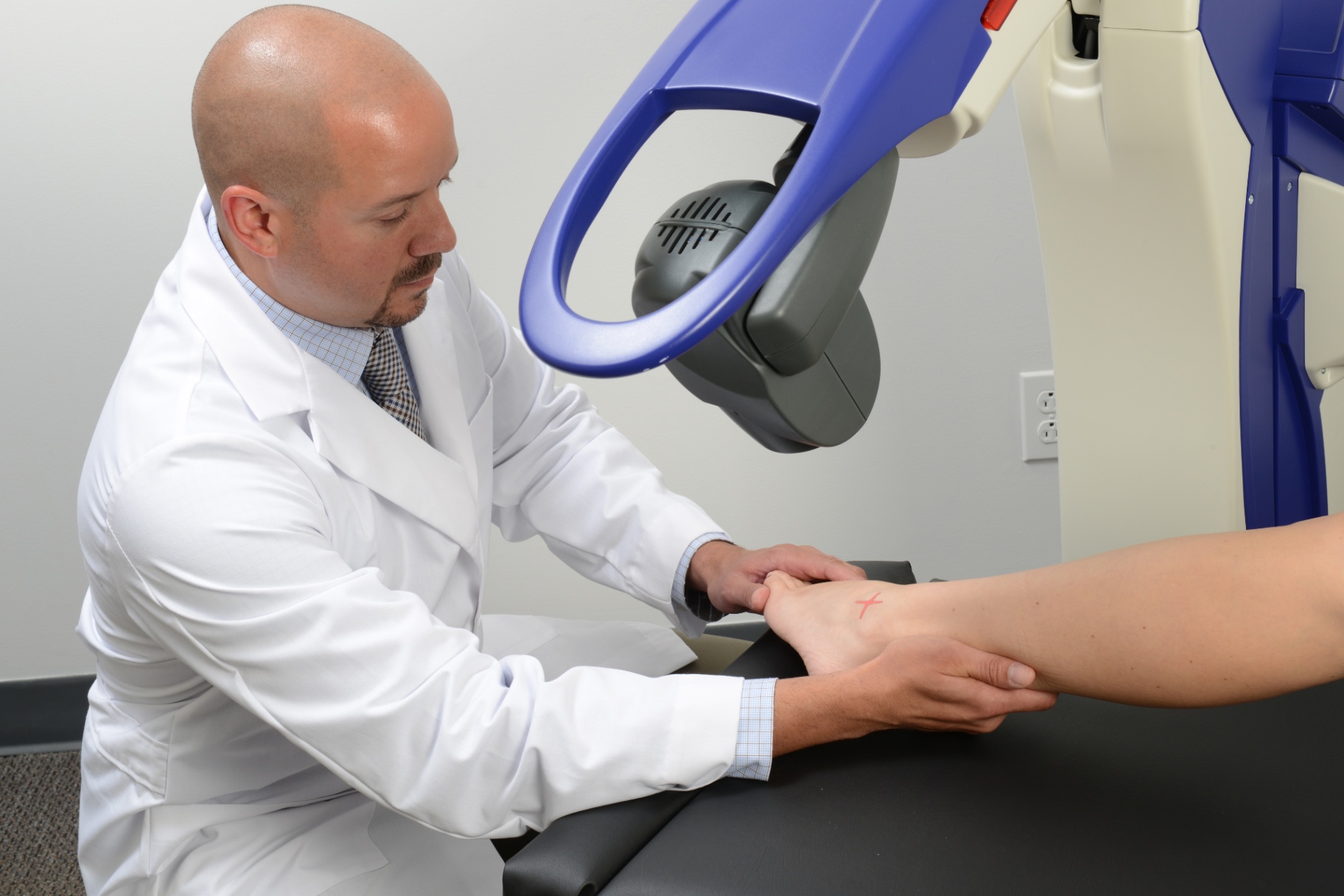 Doctor using MLS robotic laser therapy on patient