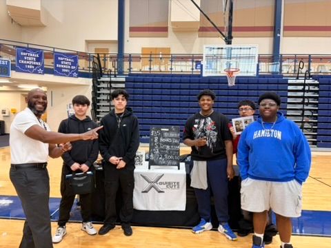 Hamilton HS Career Fair - Prize Board Shot Hamilton HS students at the X Quest Life booth with the prize list chalkboard.