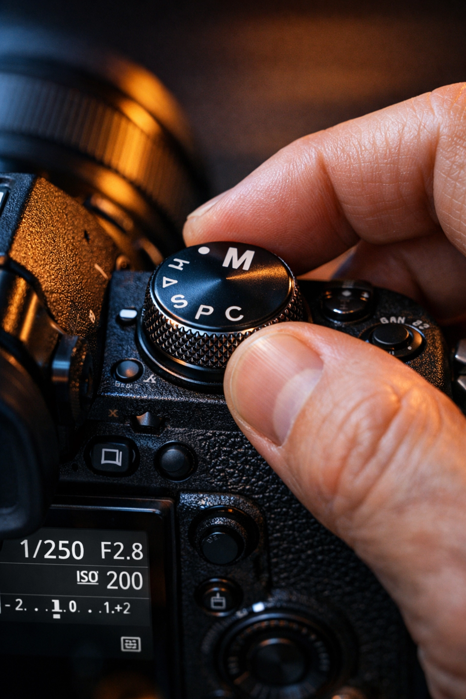 Close-up of a photographer switching to manual mode for a how to use manual mode camera tutorial.