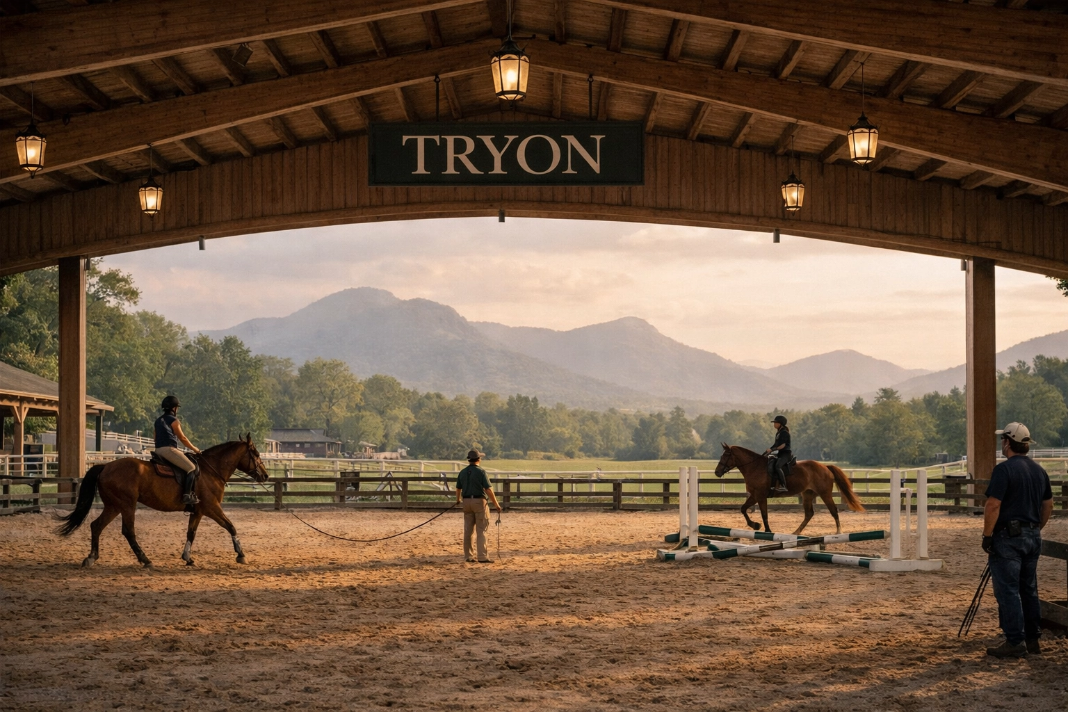 Covered riding arena at Tryon equestrian facility with horses training and mountain backdrop