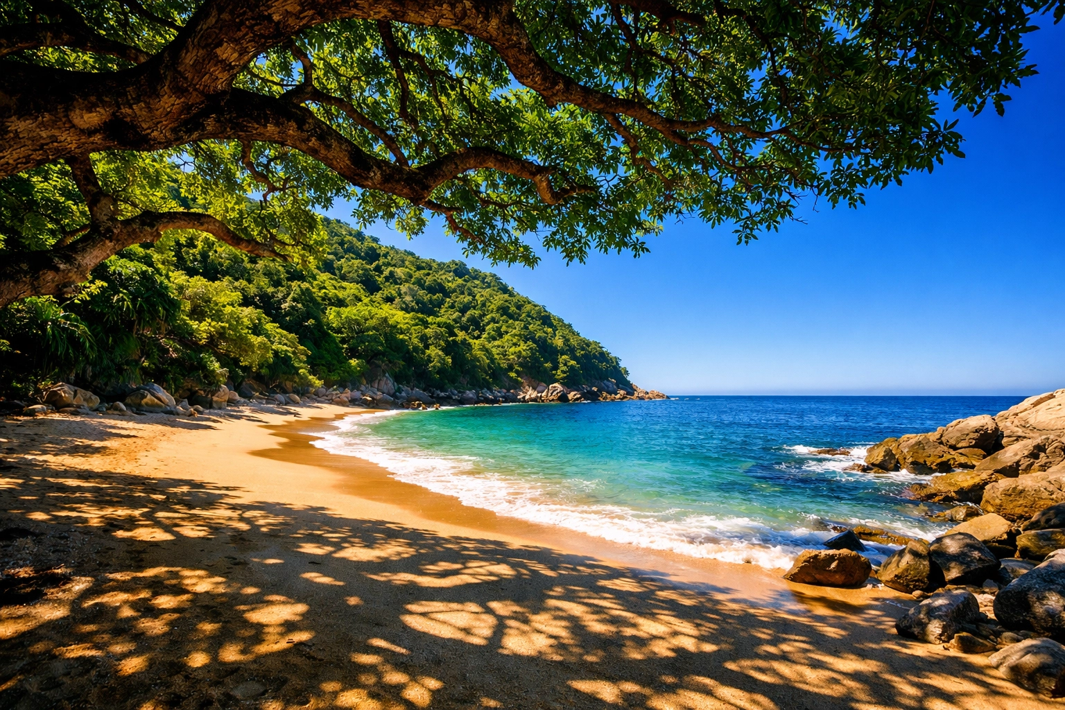 Secluded Playa Amapas beach in Puerto Vallarta with golden sand and turquoise water shaded by lush trees.