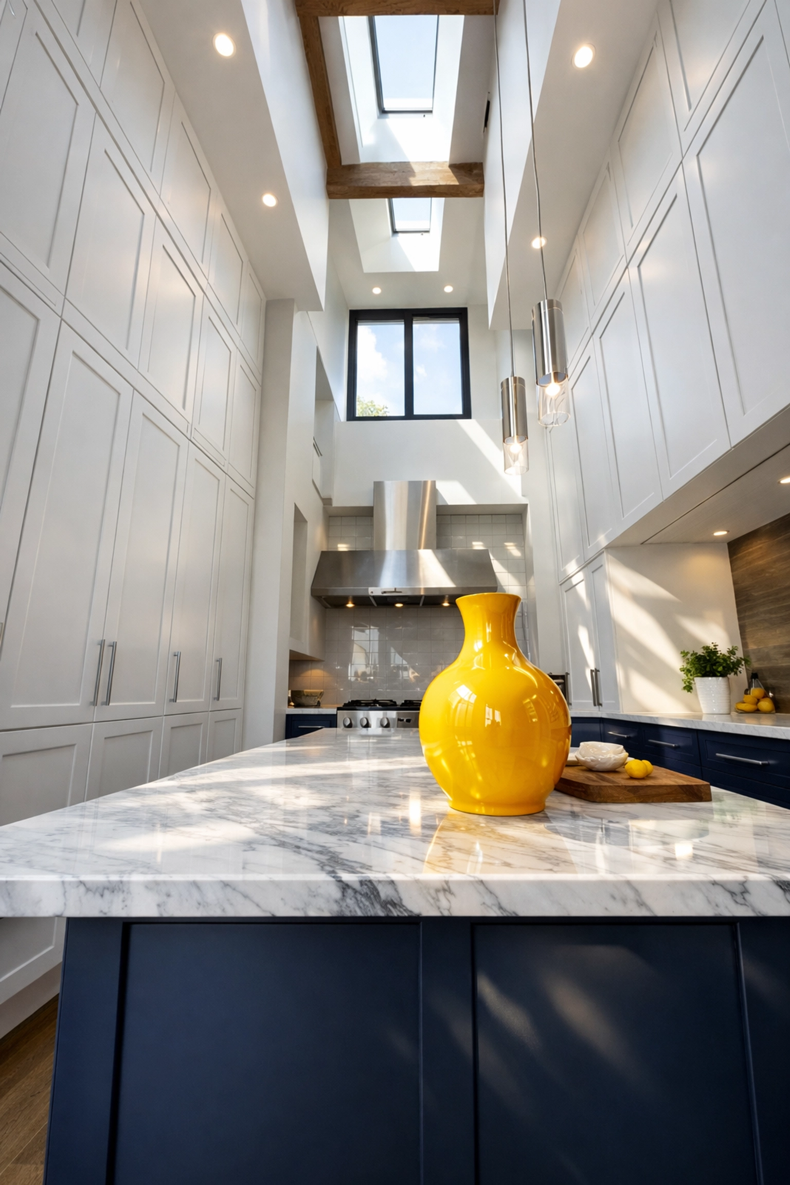 Clean modern kitchen showing tall white cabinets and a blue island, perfect for the top-to-bottom cleaning rule.
