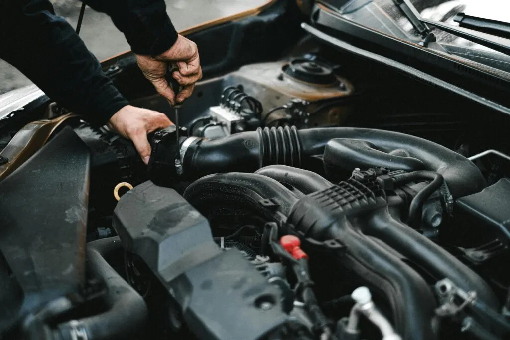 Mobile auto technician inspecting a car intake system onsite
