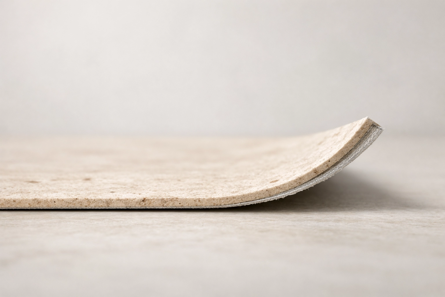 Close-up of ECO-FLEXI MCM flexible stone panel in Travertine Beige showing its ultra-thin 2mm profile.