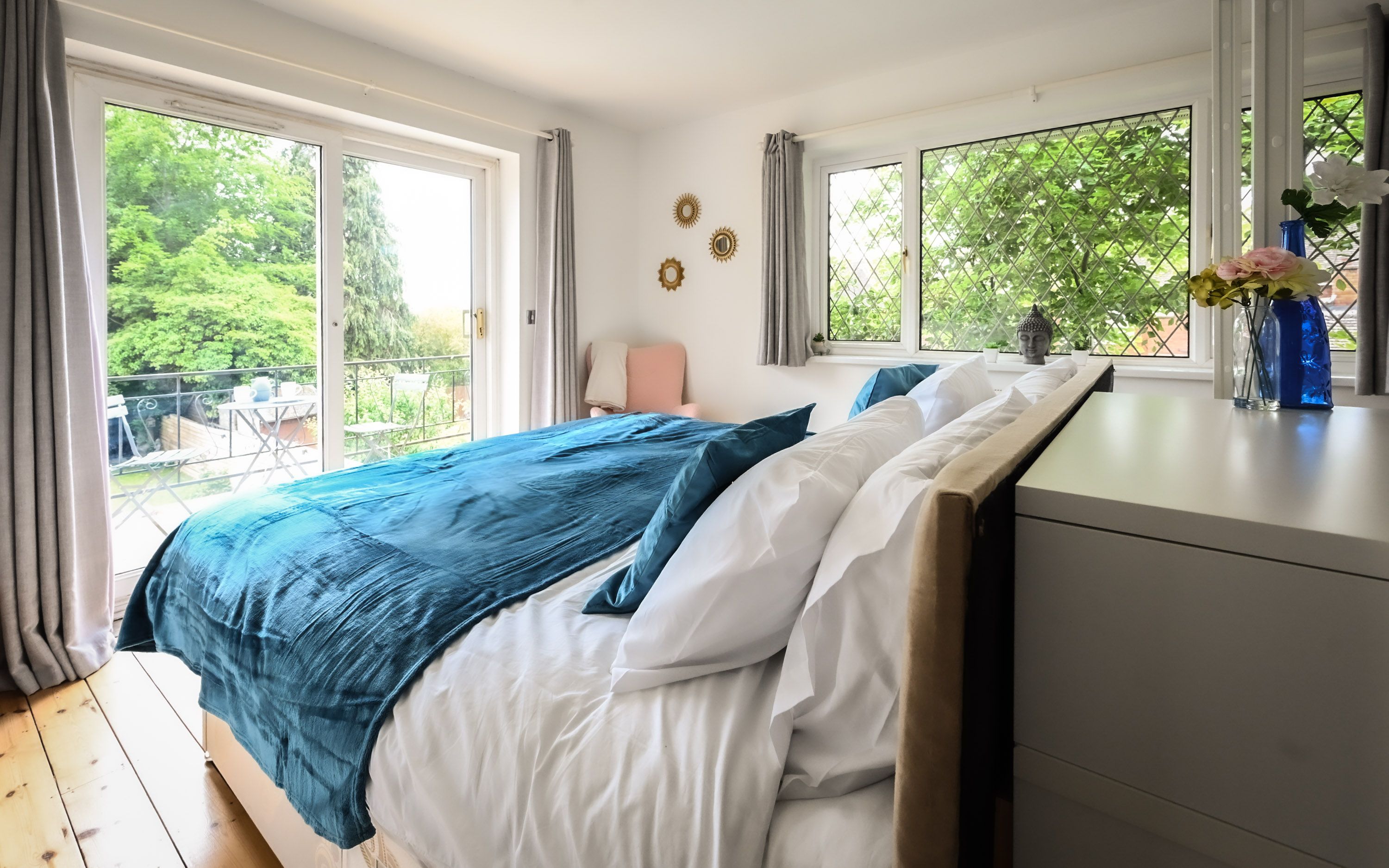 Bright double bedroom with balcony and garden view in a Jesswood Properties stay.