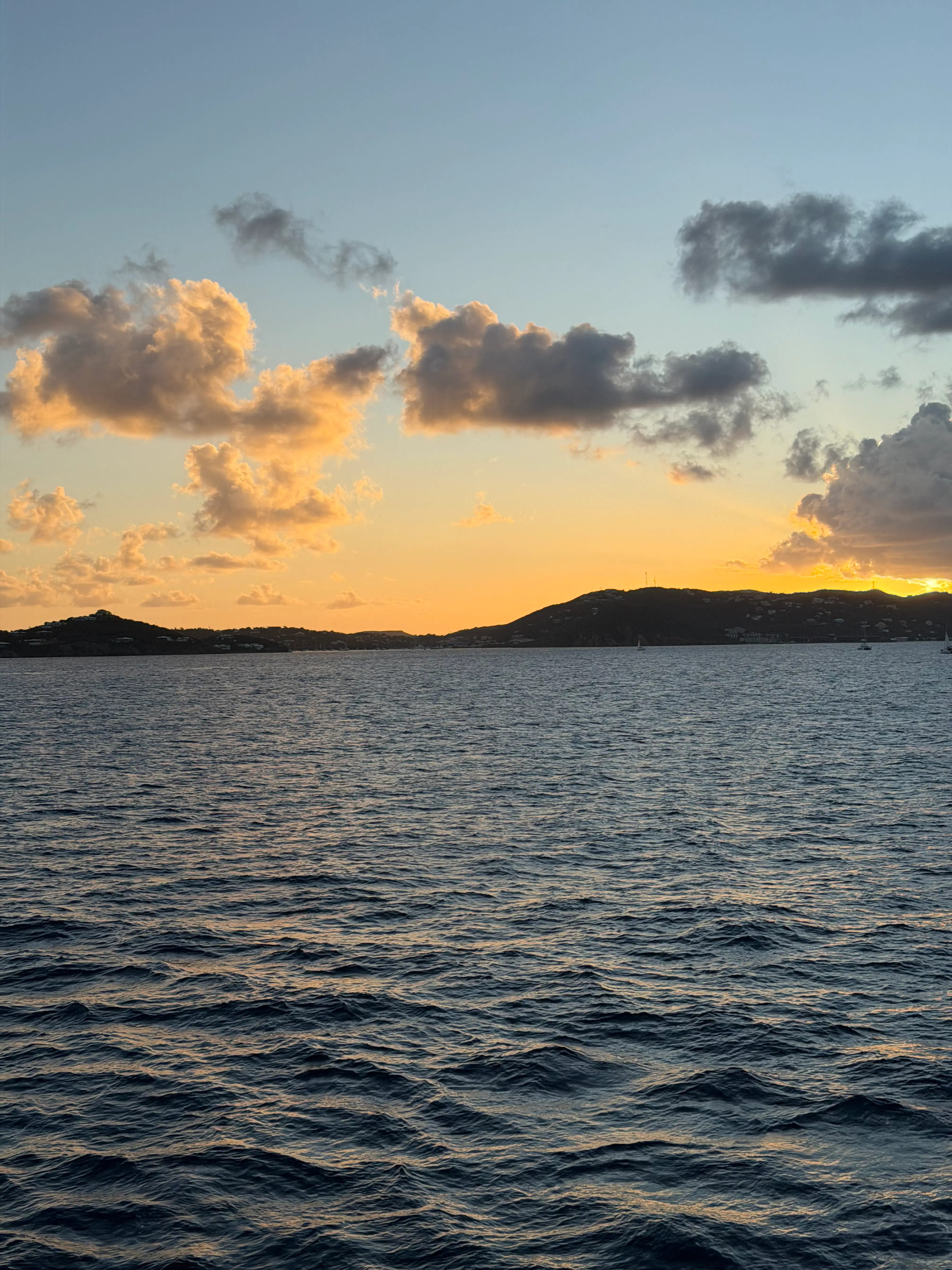 a body of water with a hill in the background
