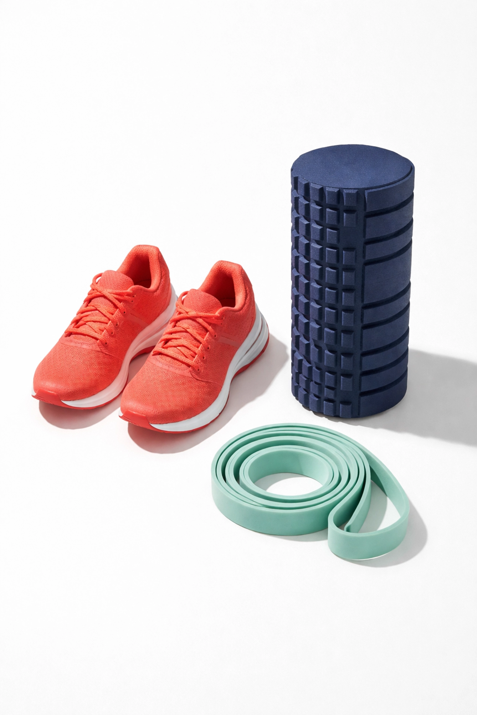 Overhead shot of running shoes, foam roller, and resistance band symbolizing balanced workout routines