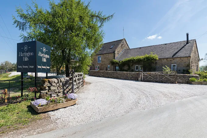 The entrance to Hartington Hills Caravan Park, showing the site entrance and surrounding countryside.
