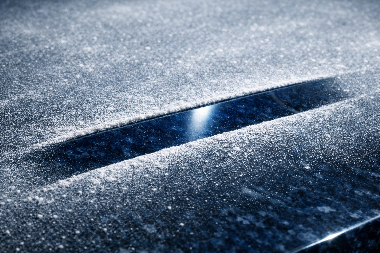 A finger swipe revealing a clean navy countertop under a layer of fine post-construction drywall dust.